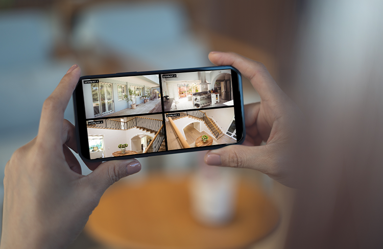 Homeowner viewing live security camera footage on a smartphone for home monitoring in Greenville, SC