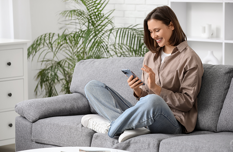 Woman using a smartphone while relaxing at home.