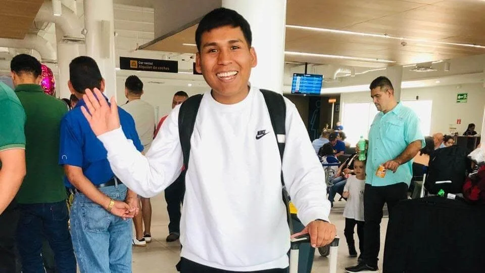 CIN graduate at airport waving