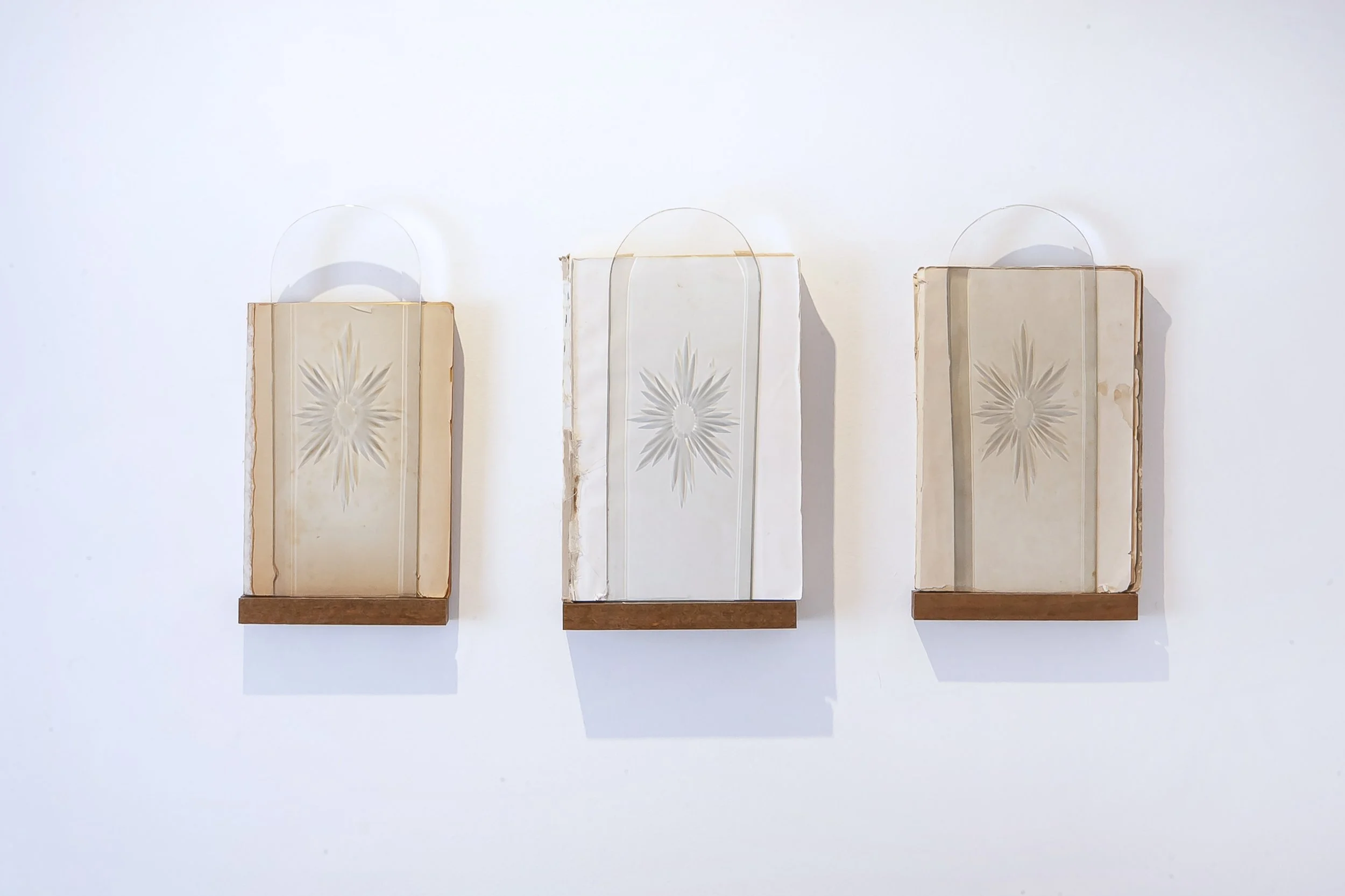  Flavia Renault, Eye of the Needle, 2023. Série: Portal. livro antigo, madeira e vidro, 23 x 16 cm cada. 