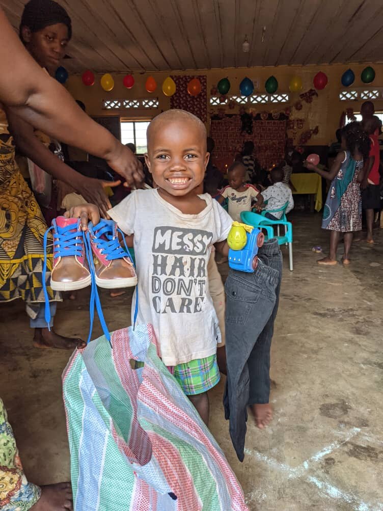 Kule is happy with his new shoes, clothing and toy