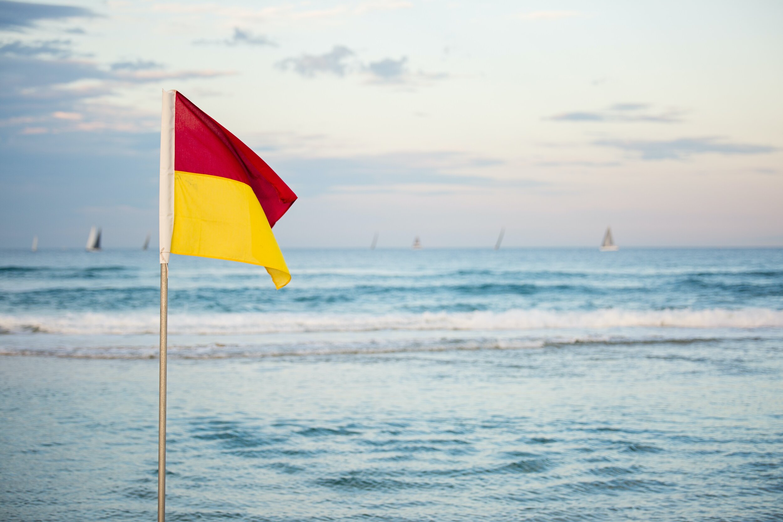red-and-yellow-flag-standing-near-beach-1199182.jpg
