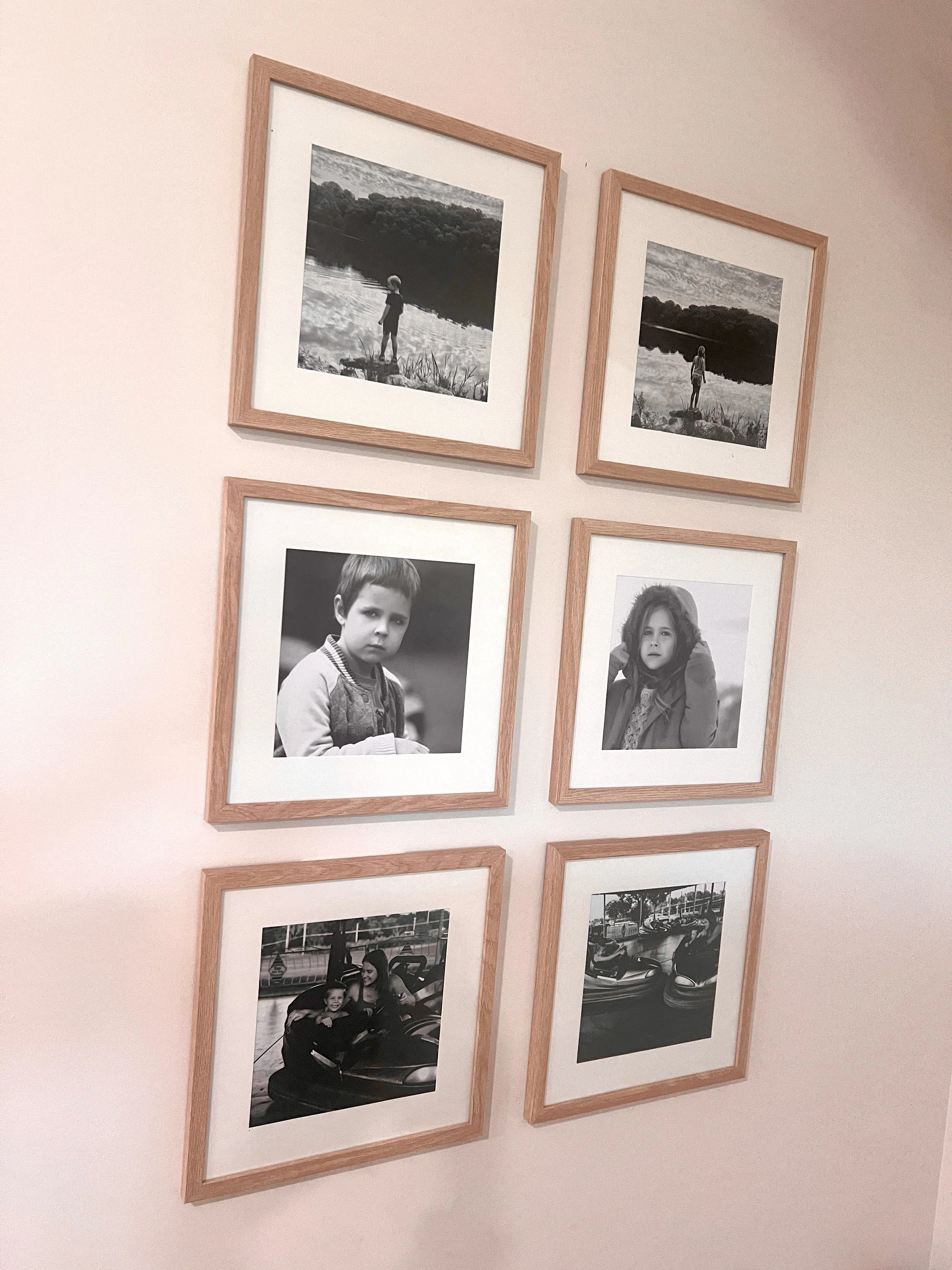 Family gallery wall with large prints and individual portraits displayed in a living room