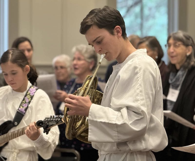 Musicians from St. Gregory's youth group play guitar and French horn with choir in background