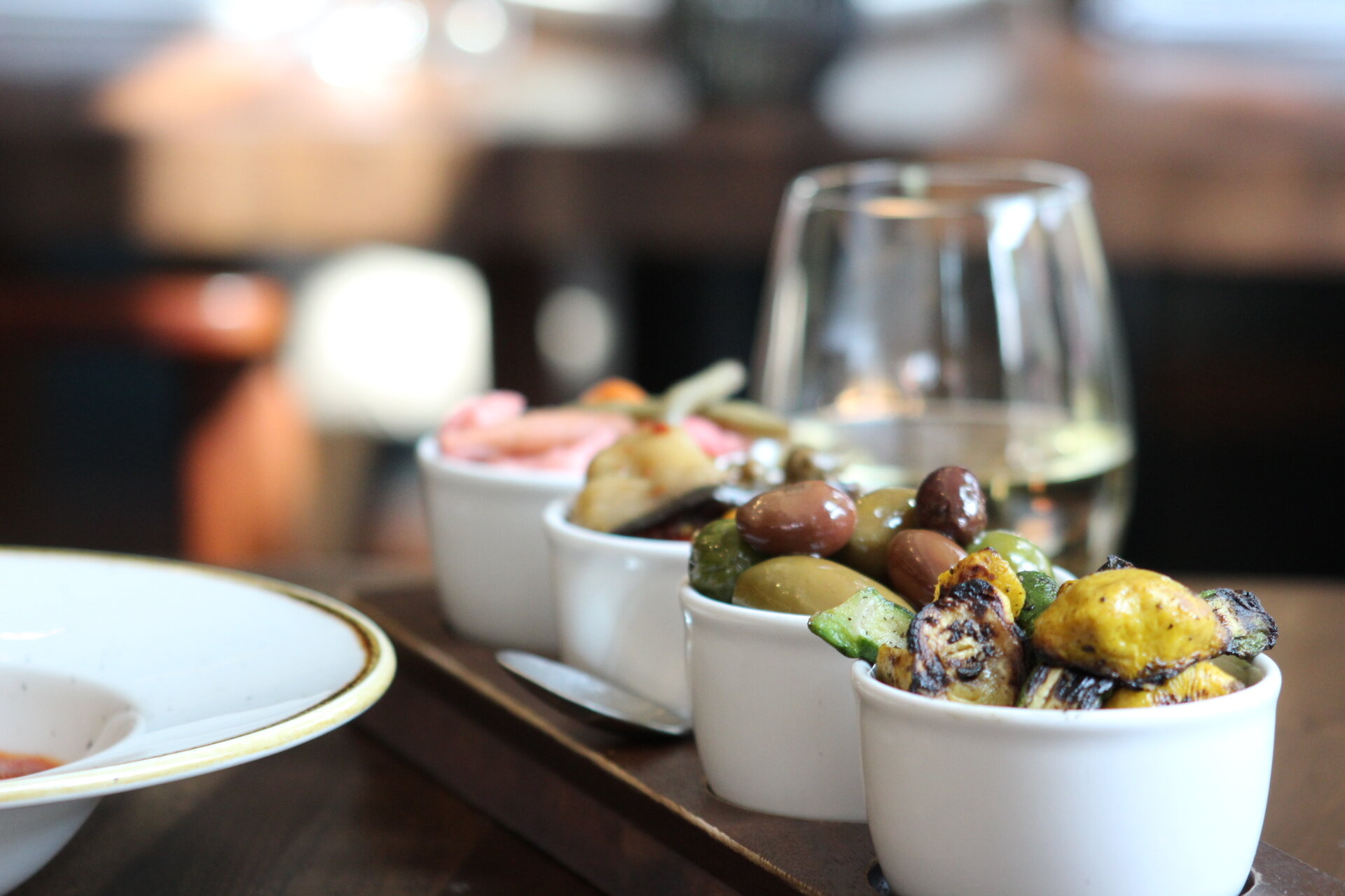 Assortment of aperitivos and a glass of wine, a delightful selection.