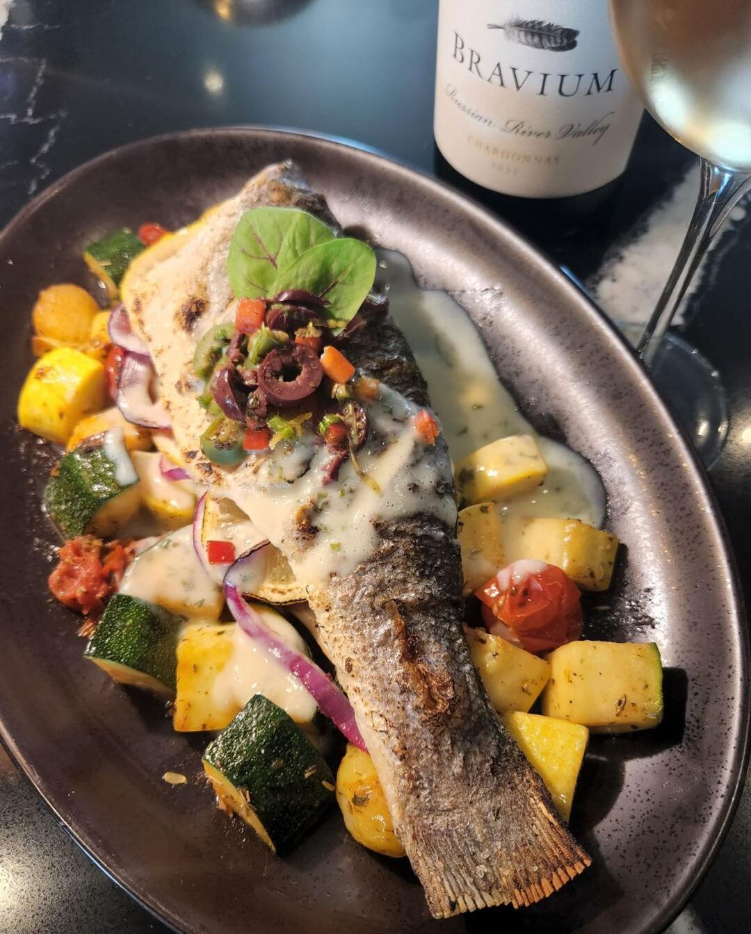 Weekend vibes loading now!!! 

👉🏼 Whole-roasted Branzino (also known as European Sea Bass) stuffed with lemon and herbs, over roasted summer vegetables, topped with lemon sauce and olive relish

🍷 Pictured with @braviumwines Chardonnay - cheers!!
