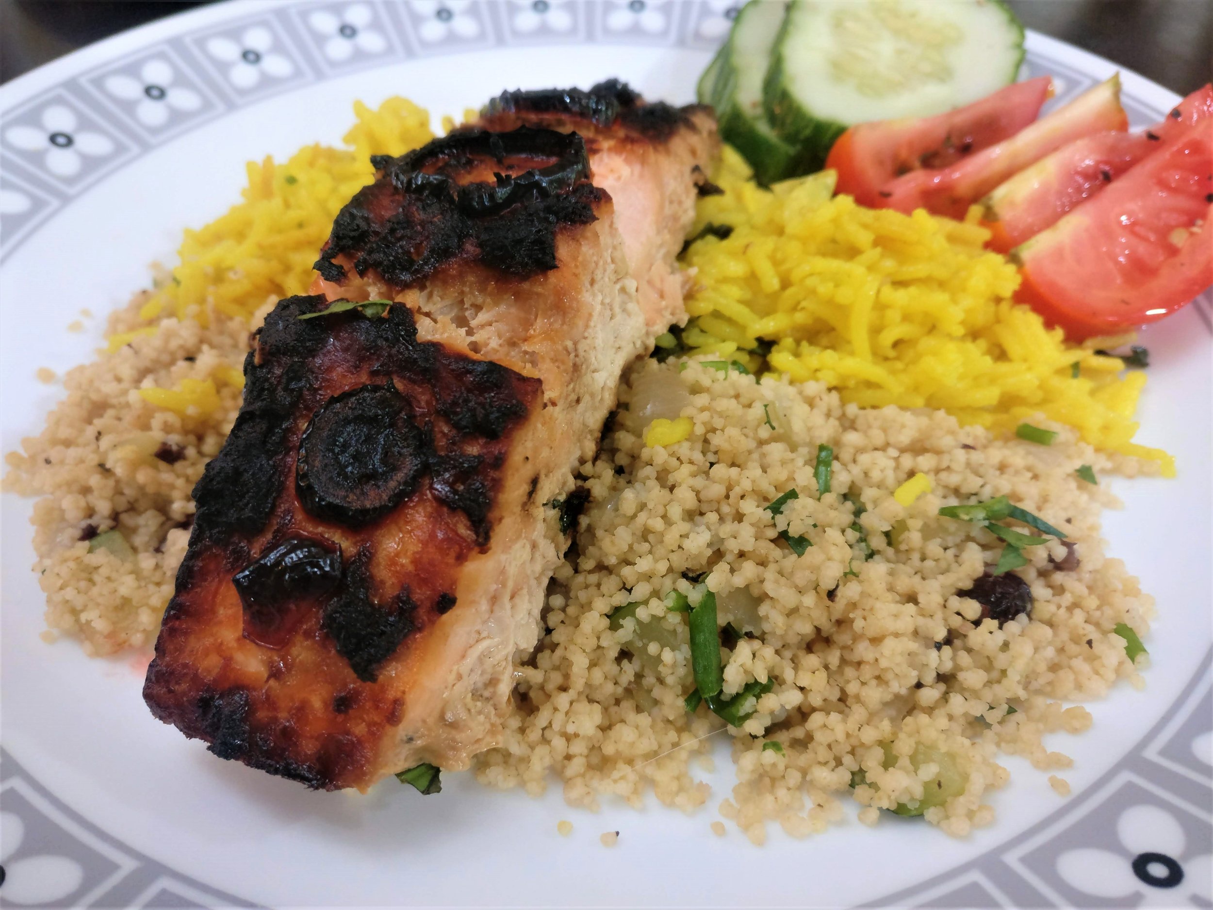 That char is to die for! - Salmon is plated with Couscous with cranberries and a Coconut tumeric basmati rice.