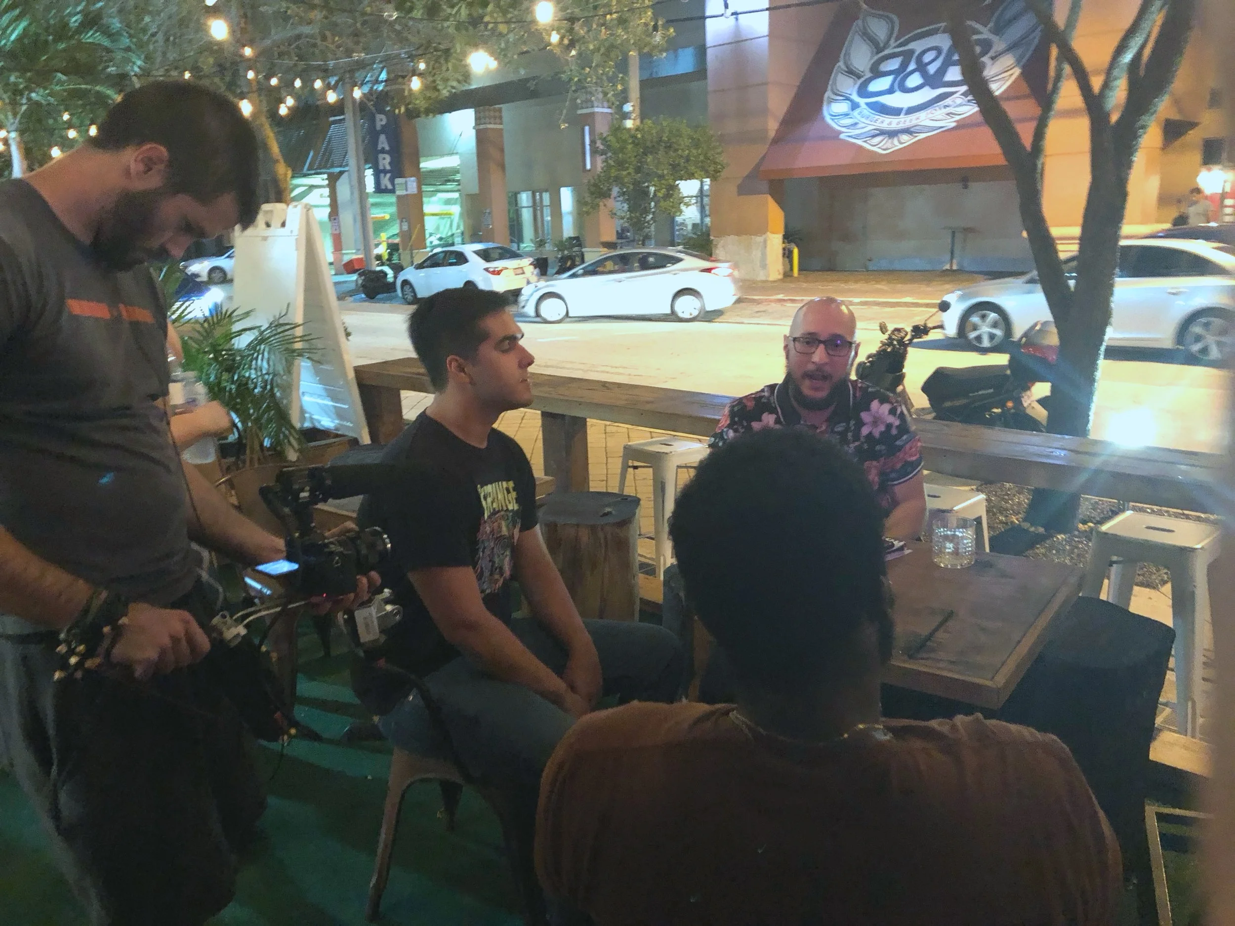 Cinematographer Greg Kerrick films Sebastian Mattar & Rudy Wilson while they chat with friends and comics outside of a Miami Comedy show at Redbar in Brickell, Miami.