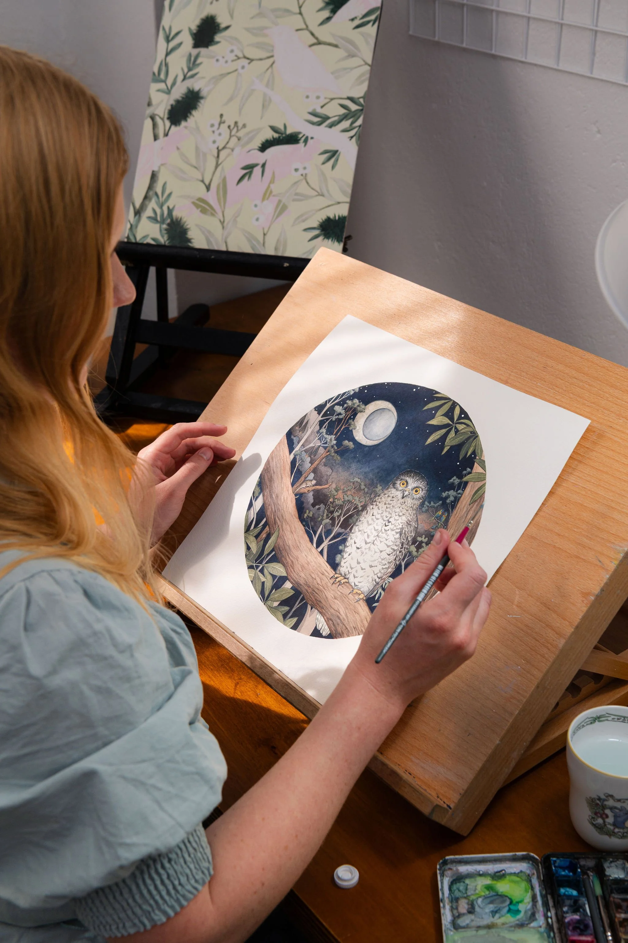 Close-up of Ingrid’s hands painting in her studio, capturing creative process