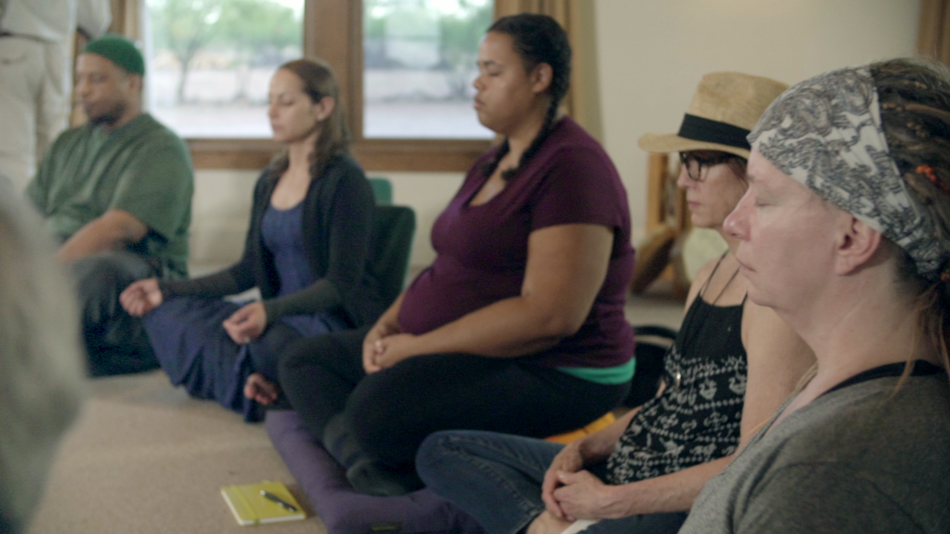 Film participants in mediation pose meditating