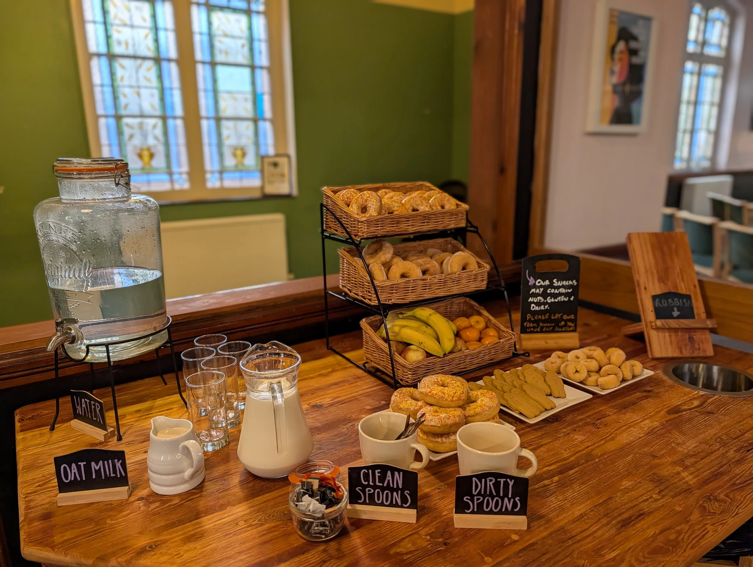 A wooden table containing doughnuts, snacks and fruit available free of charge during a Sunday Service at Darlington Vineyard Church, Salt Yard.