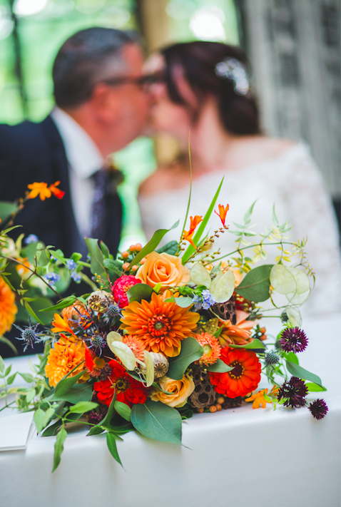a brides bouquet containing Dahlia, Forget me nots, roses, zinnia, honesty, eryngium, cornflowers, crocosmia.