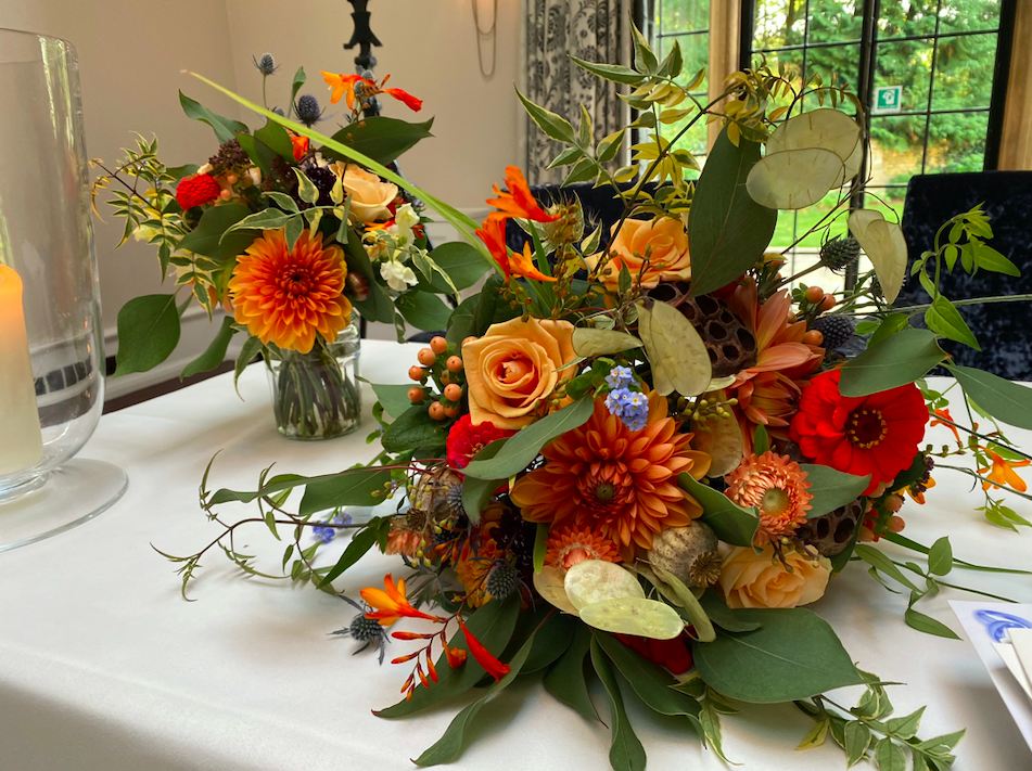 A brides bouquet in autumnal colours including Dahlias, roses, zinnia, Eucalyptus
