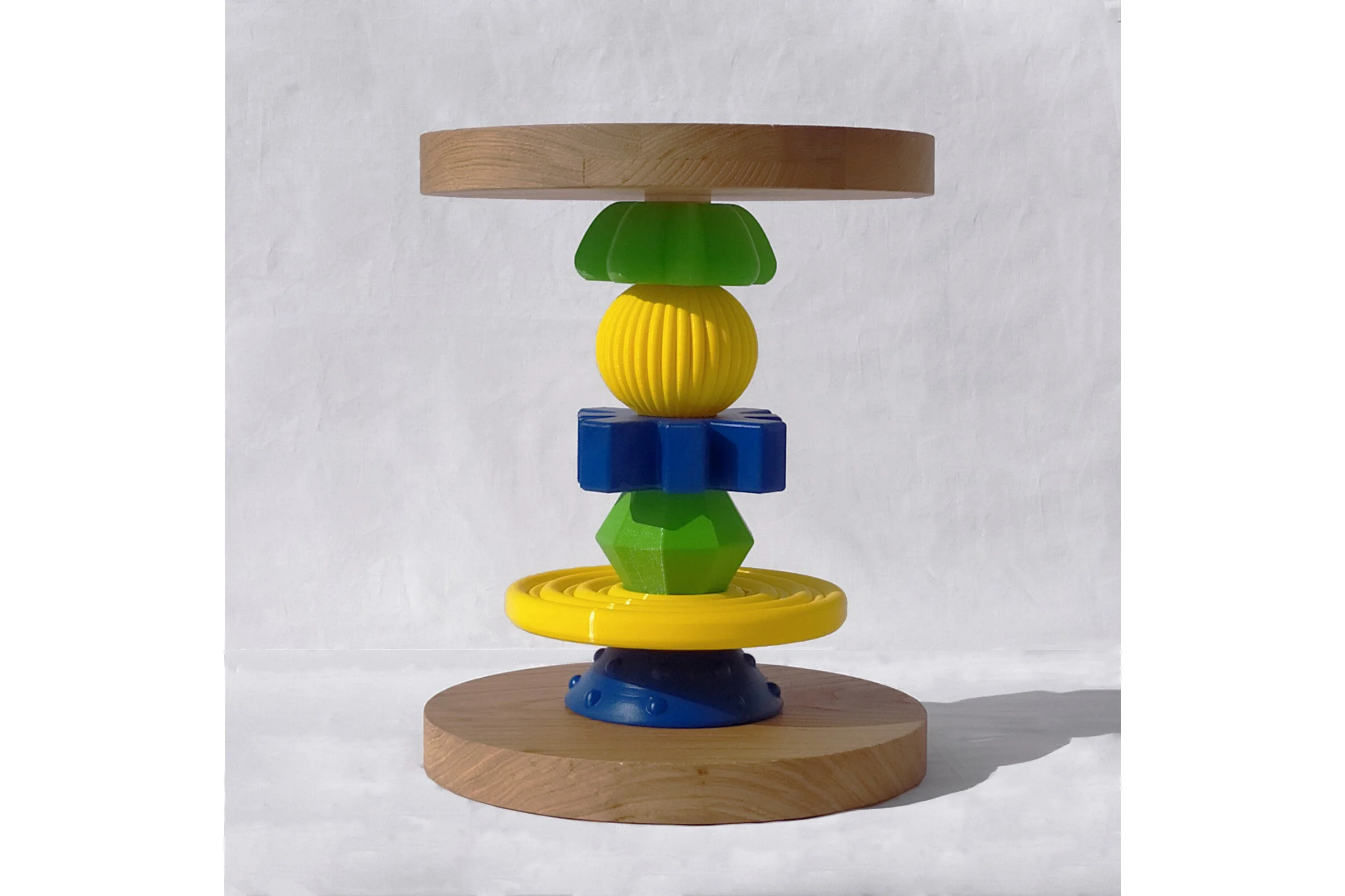  Oggetto: Sgabello/comodino   Anno: 2020  Materiali:  PLA plastica riciclata stampata in 3D e legno di rovere   Descrizione: Lo sgabello è in legno alto 60 cm e largo 45 cm. Composto di tre pezzi smontabili: seduta, base, struttura centrale. Un gioco