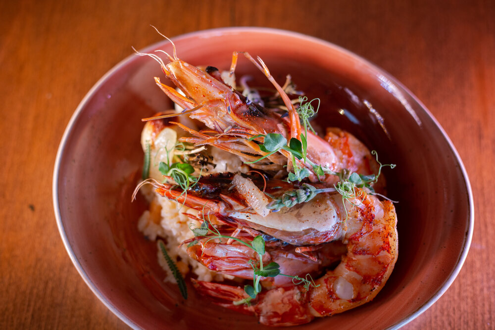 Giant prawn in bowl with lavender and fresh herbs