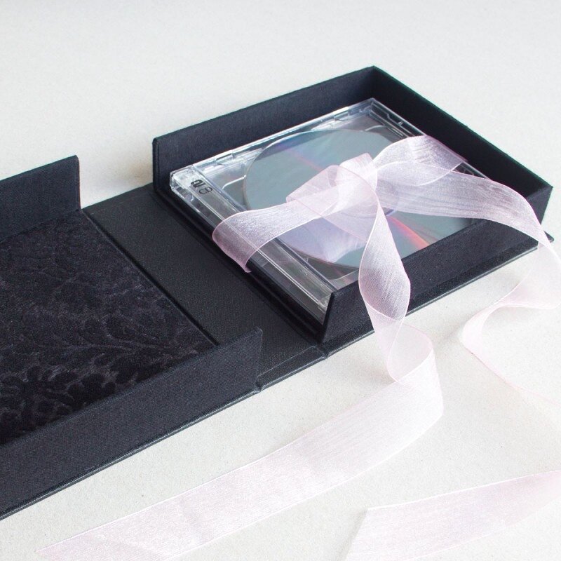 Interior of box with black flocked paper and CD