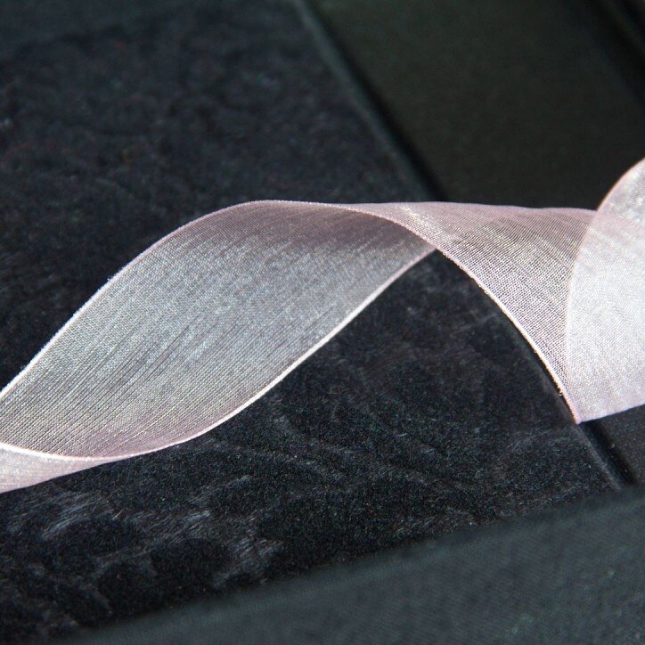 Close up of black flocked paper and sheer pink ribbon