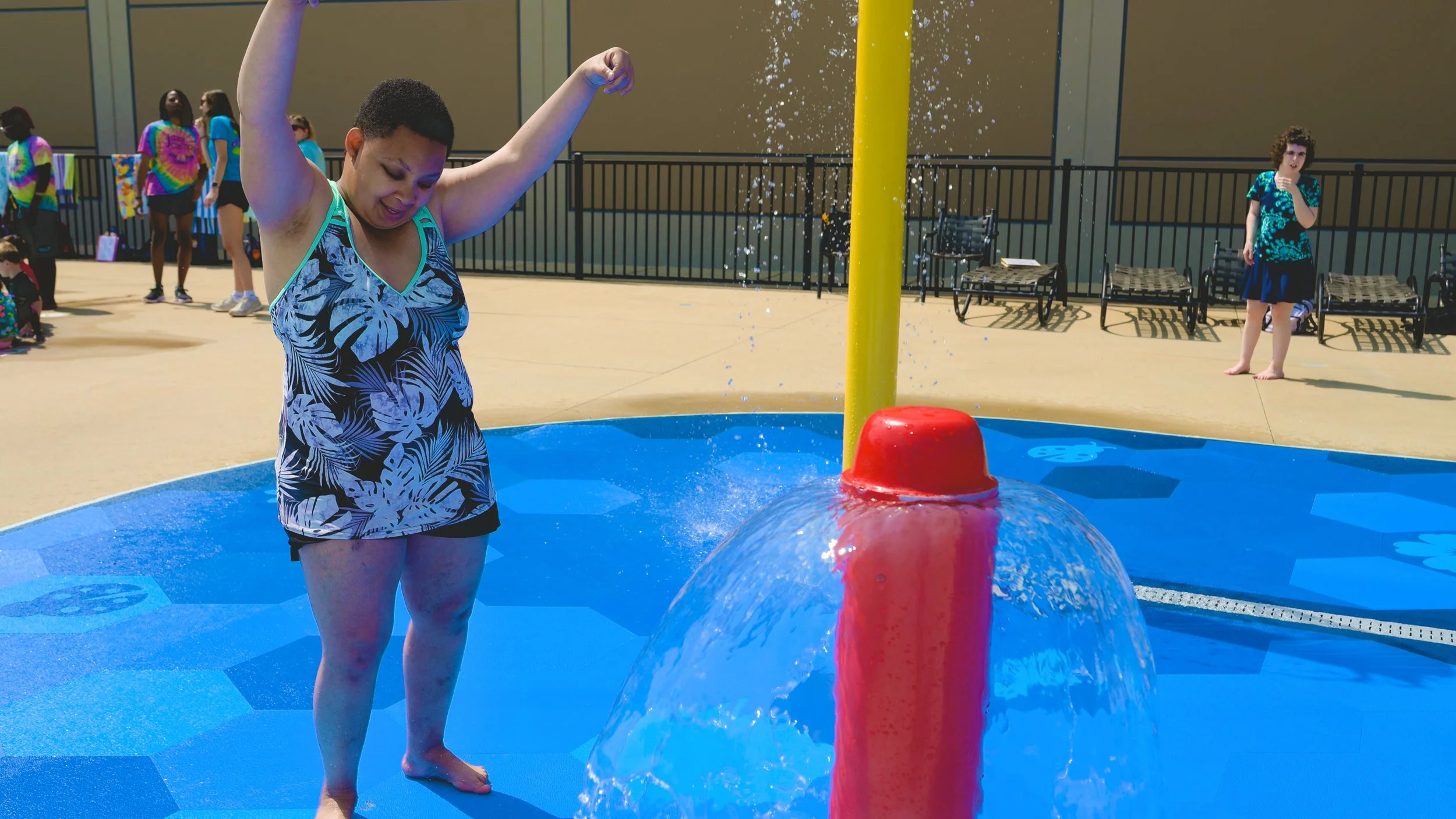 Female guest playing on splash pad with Life Floor splash pad flooring, aquatic safety surfacing