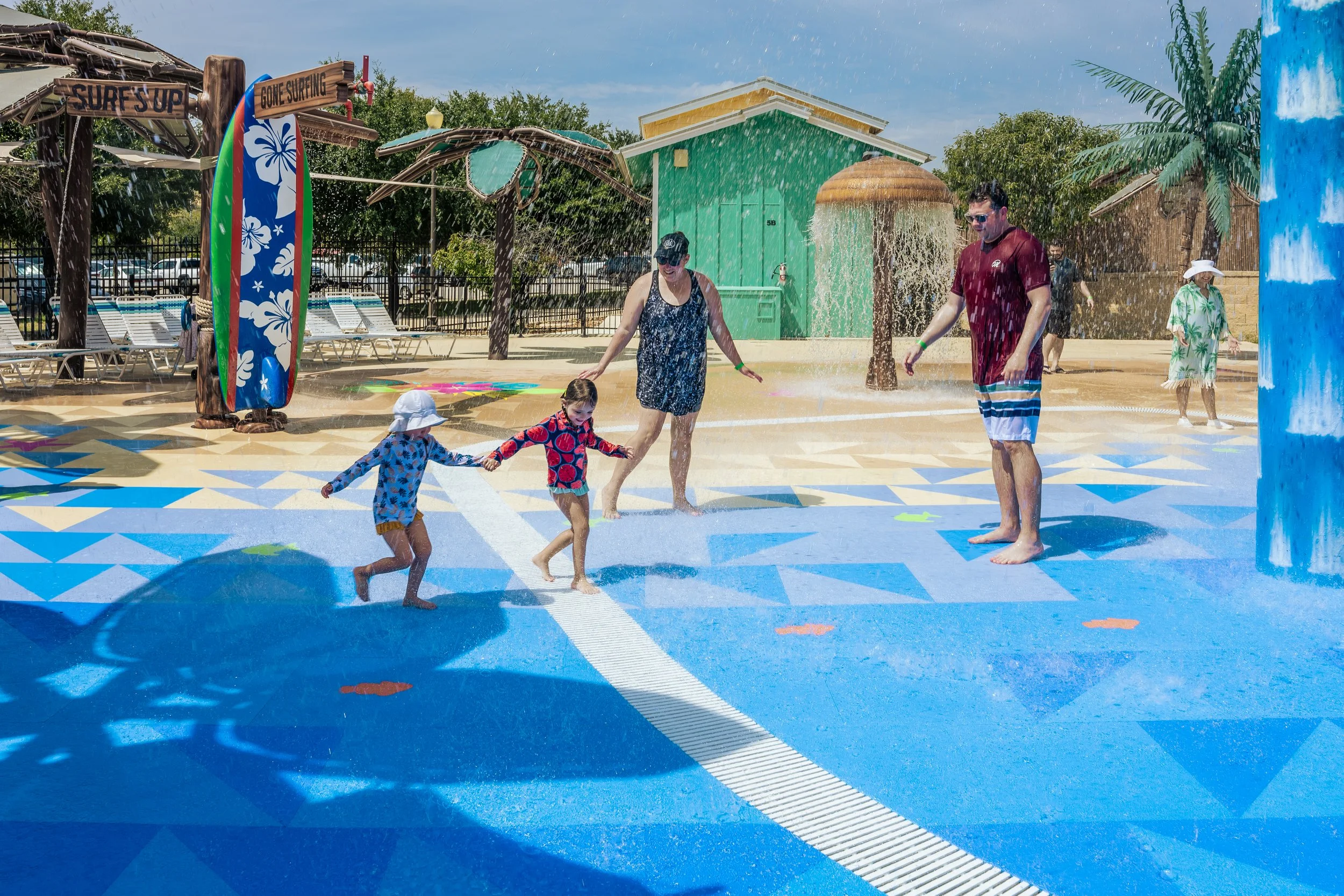 Family playing on splash pad with Life Floor certified aquatic surfacing, safety tiles, splash pad flooring, splash pad safety