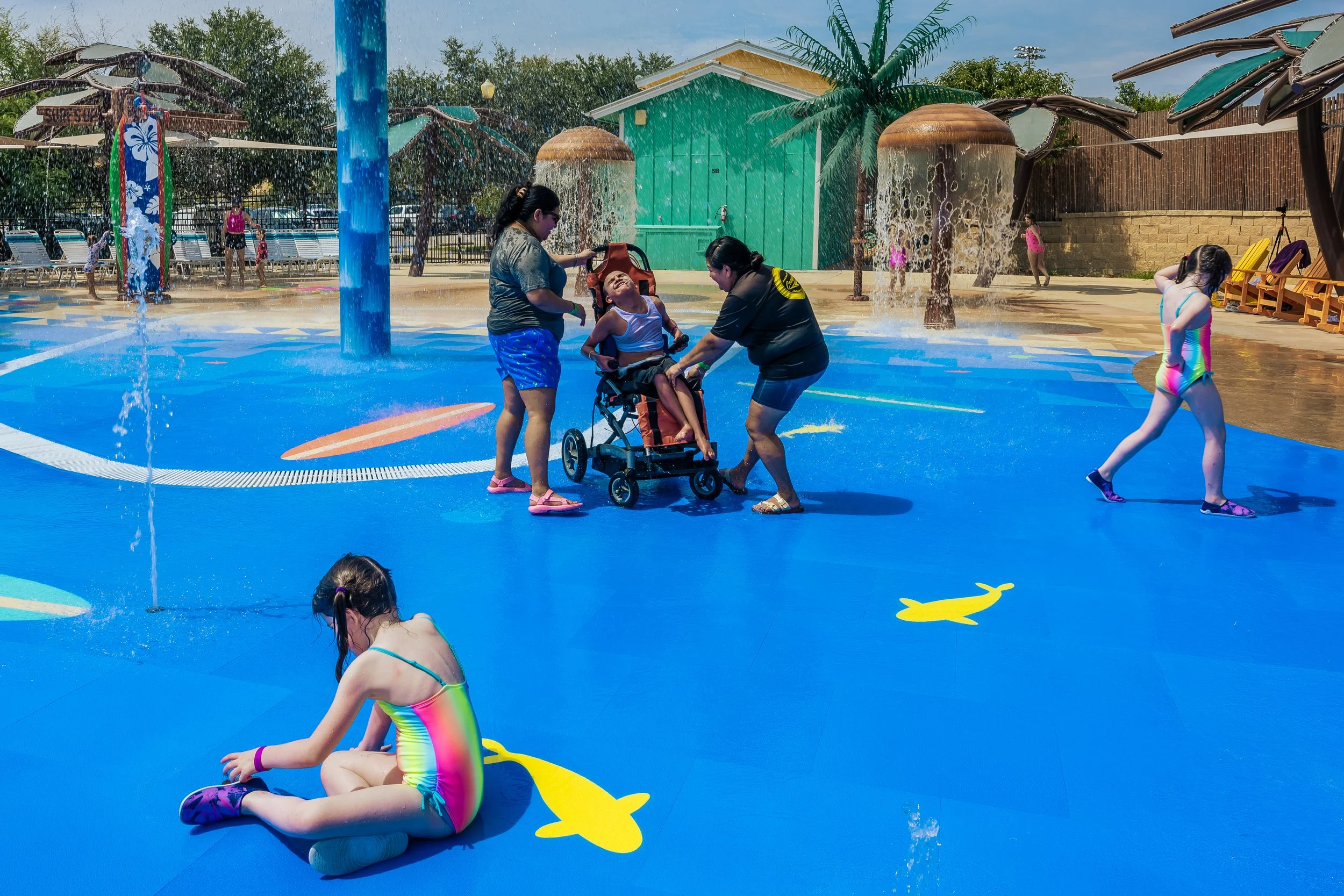 Children playing on a splash pad with Life Floor splash pad surfacing, inclusive design, wheel-chair friendly