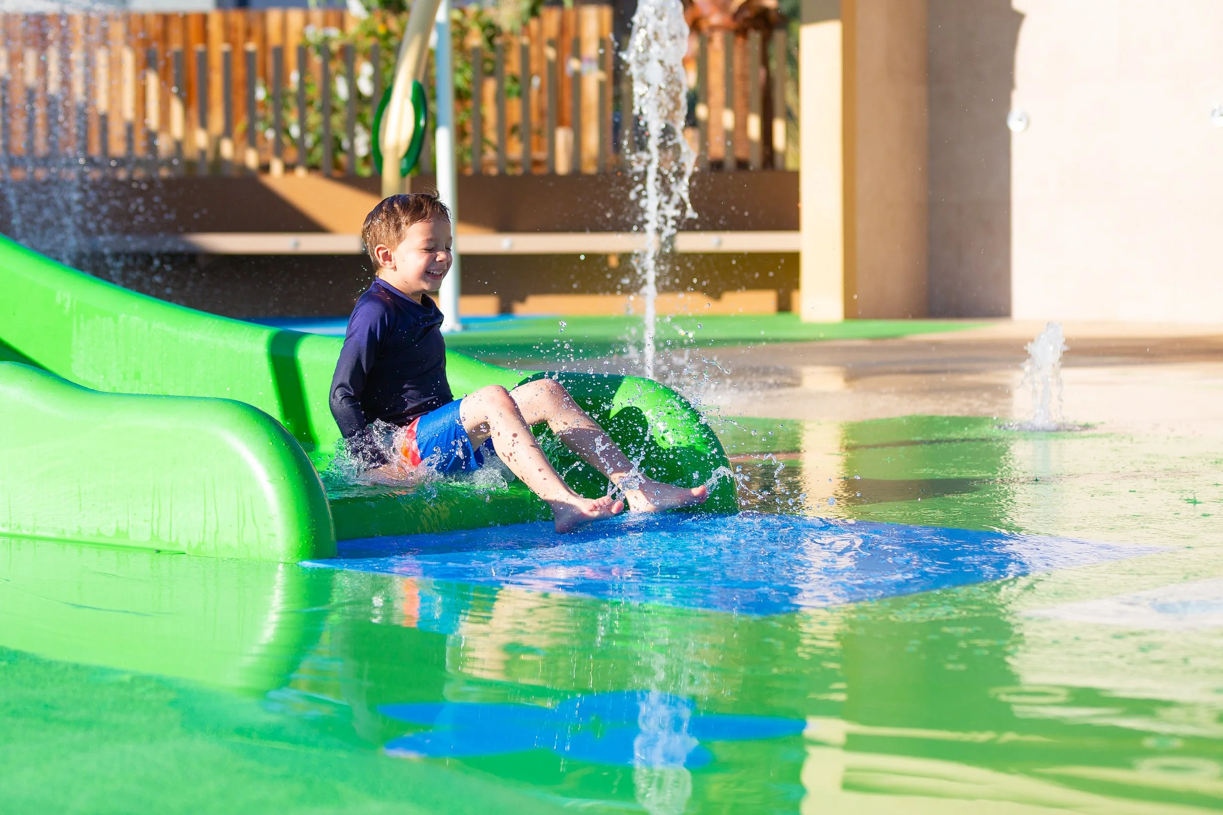 Boy on Slide, Safety Surfacing, Aquatic Safety Surfacing, Slide Landing Pad