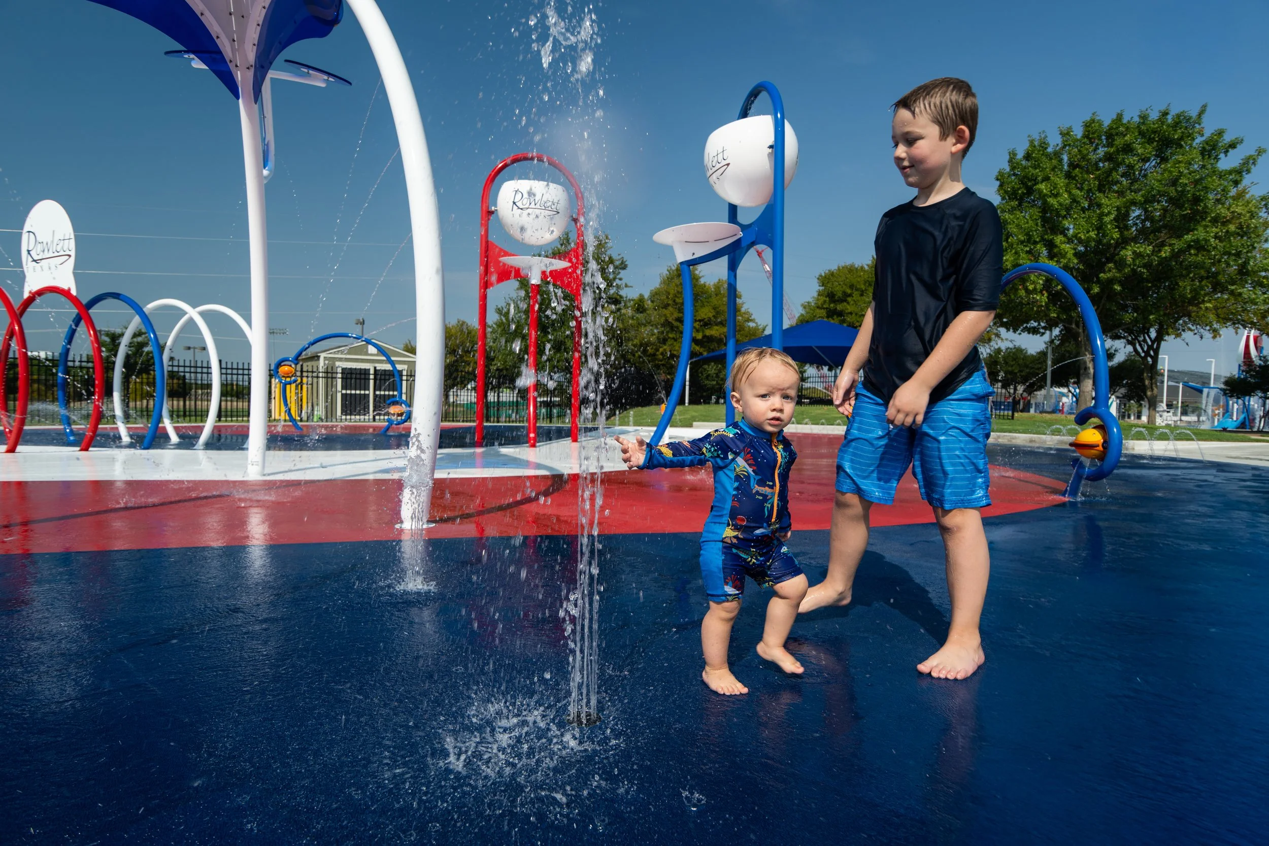 Bold red, white, and blue Life Floor design adds slip resistance and visual impact to Rowlett's community splash pad.