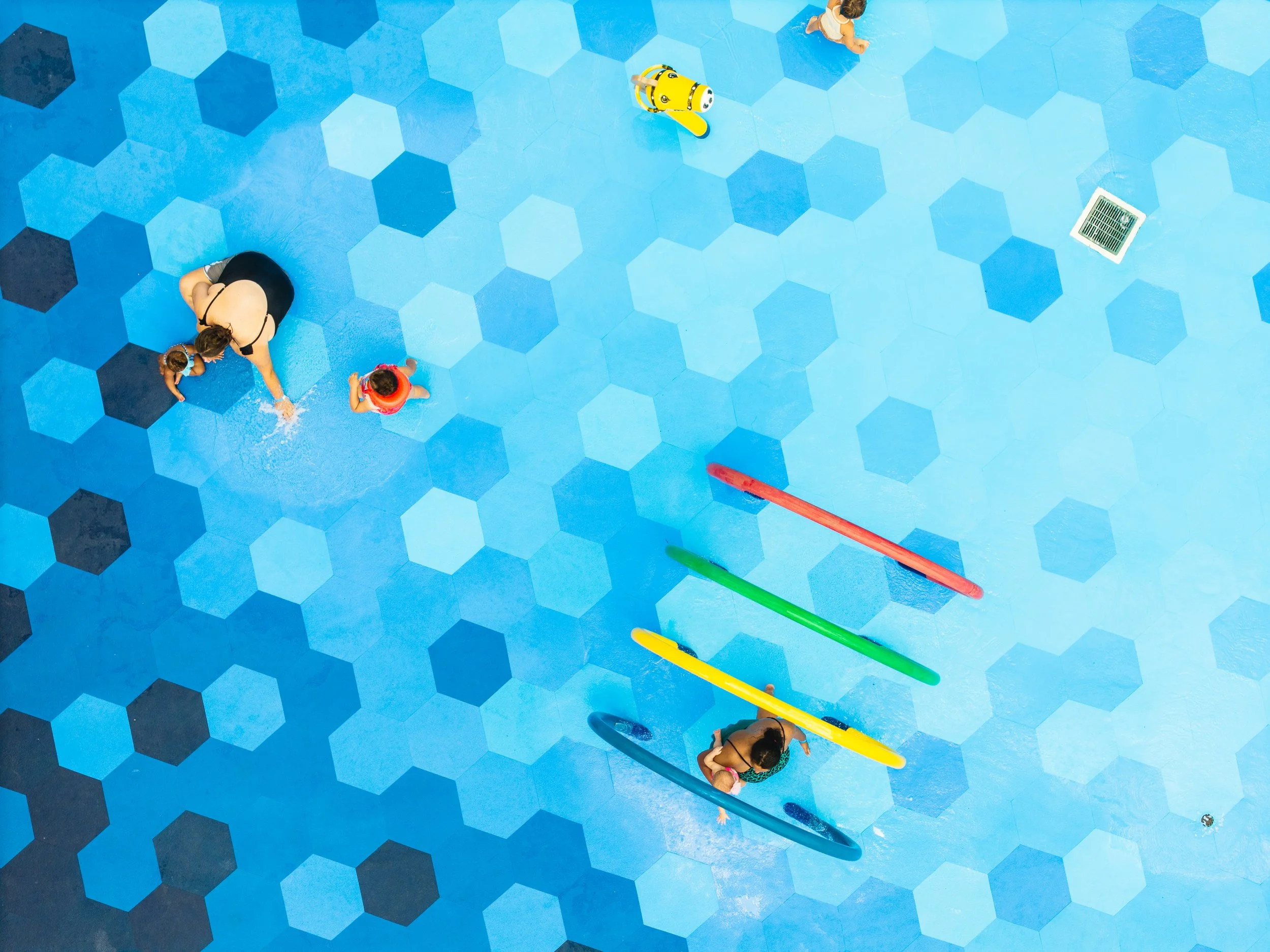 Aerial photo of family playing on splash pad with hexagon splash pad tiles, Life Floor splash pad tiles