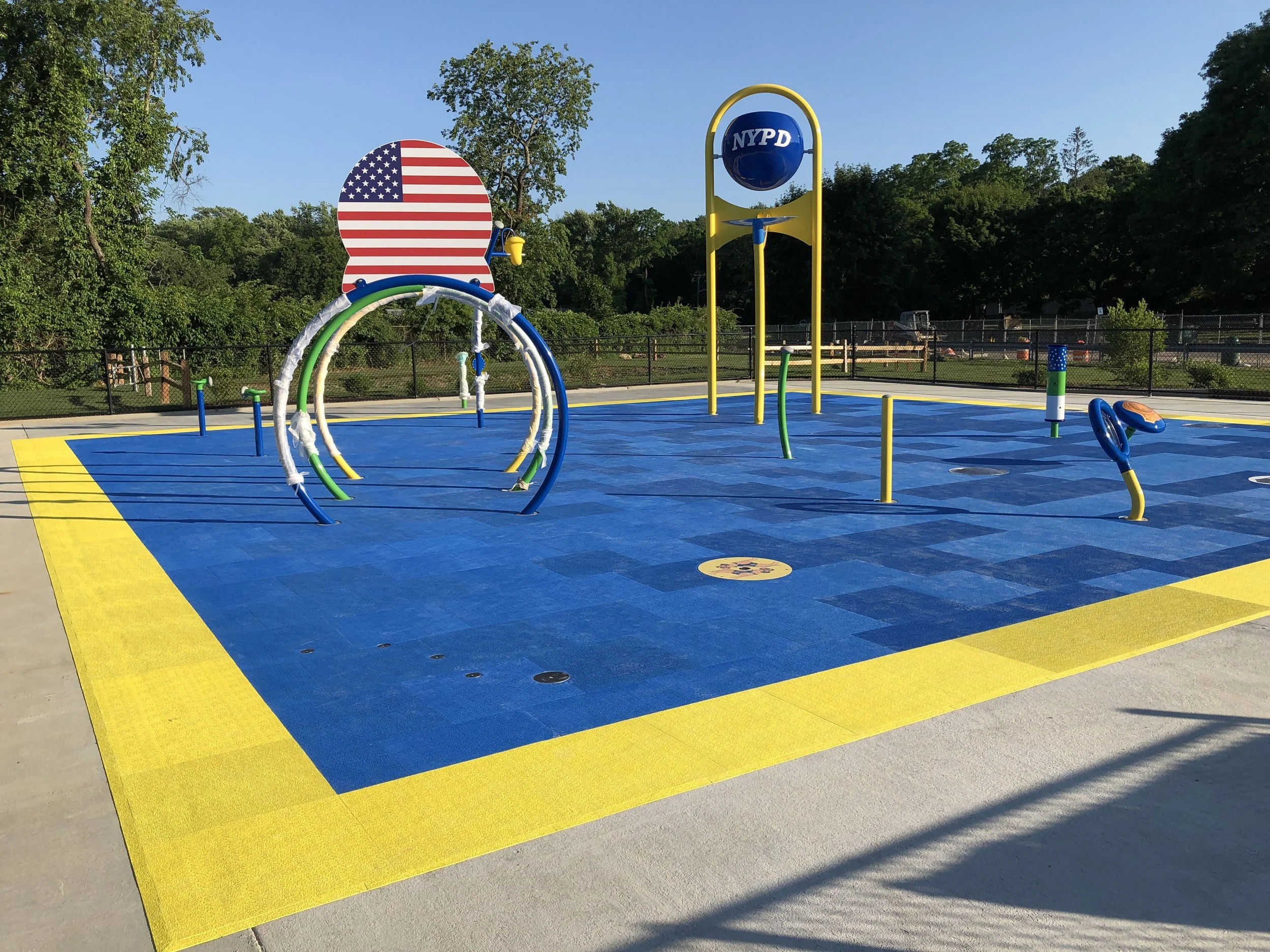 Yellow and blue splash pad with safety surfacing