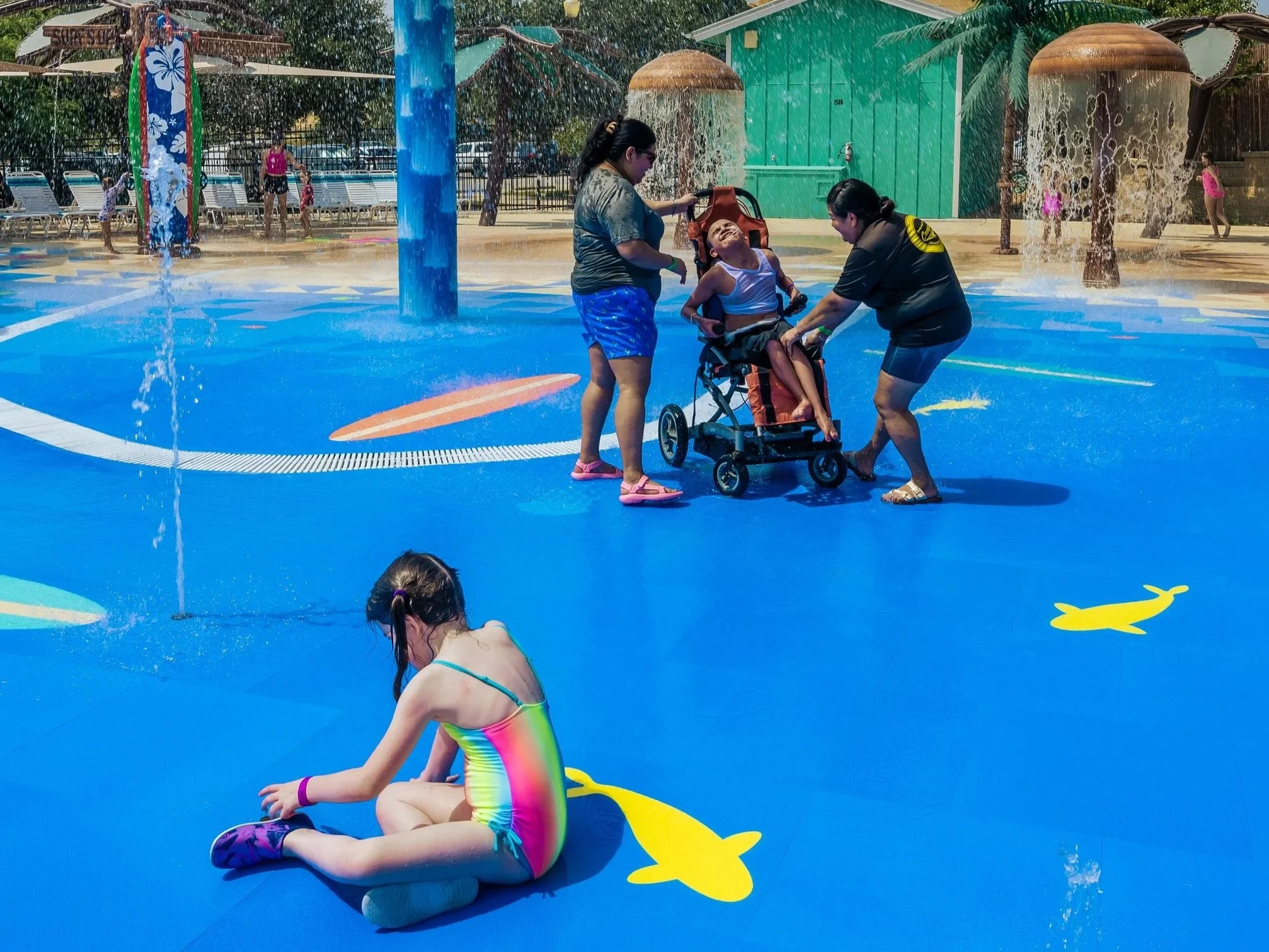 Morgans Wonderland, children playing on splash pad with Life Floor splash pad tiles, child in wheelchair on splash pad. Inclusive splash pad flooring