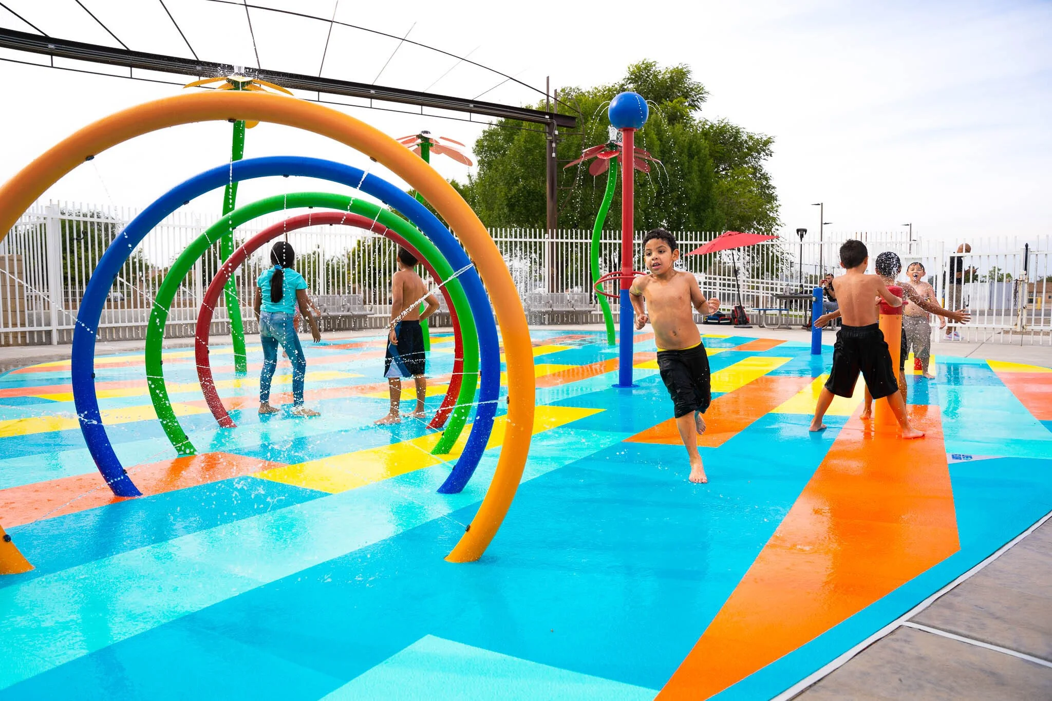 Children running on splash pad with Life Floor safety tiles, certified aquatic surface, nsf, astm, safety flooring