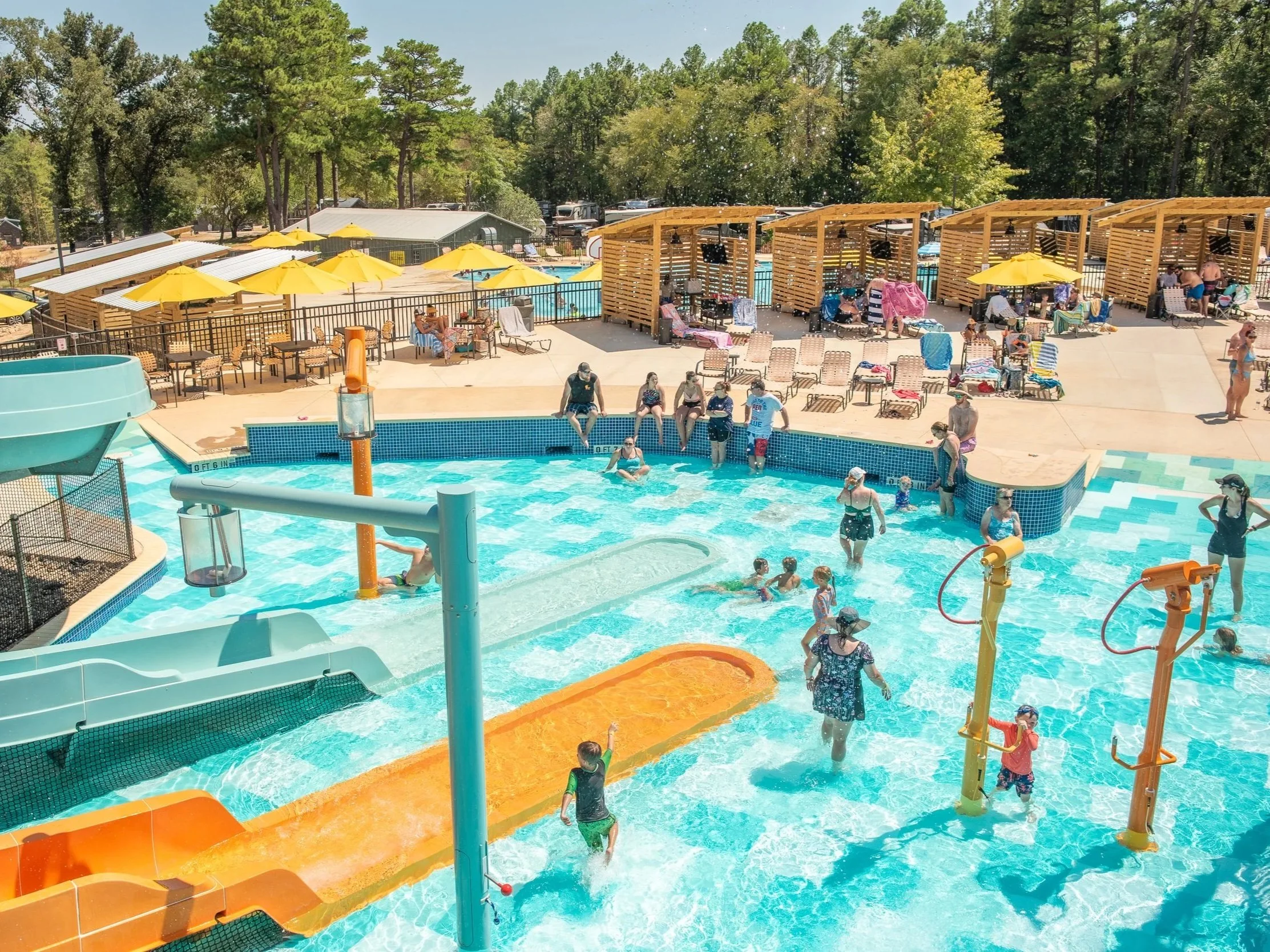 Jellystone Park Tyler, TX campground guests playing in activity pool with Life Floor aquatic safety surfacing blue and aqua tile