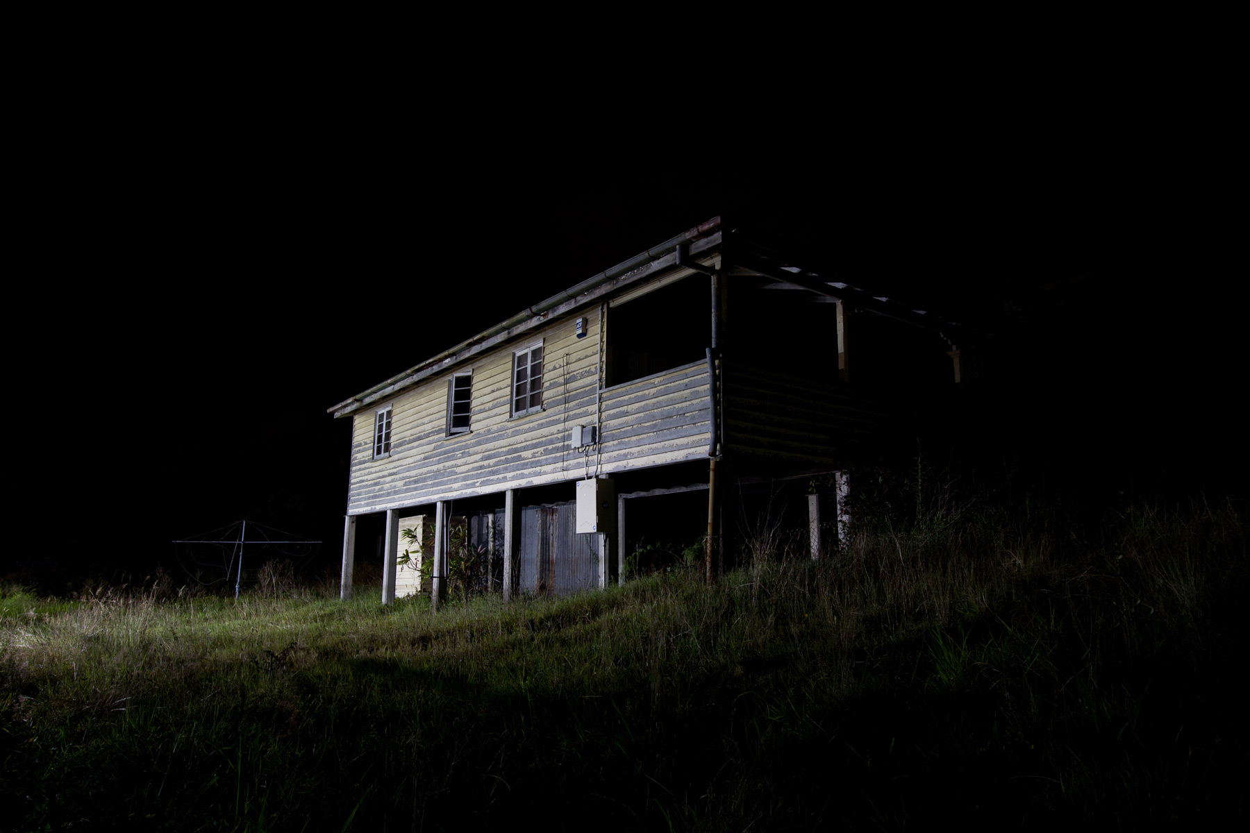 Light hitting the side of an abandoned house at night