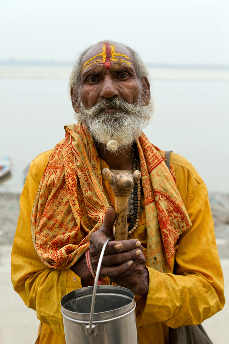 A holy man standing in front of the Ganges River in Varanasi, India