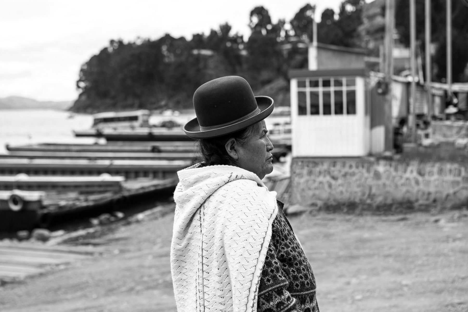 A woman wearing a bowler hat at Lake Titicaca, Peru