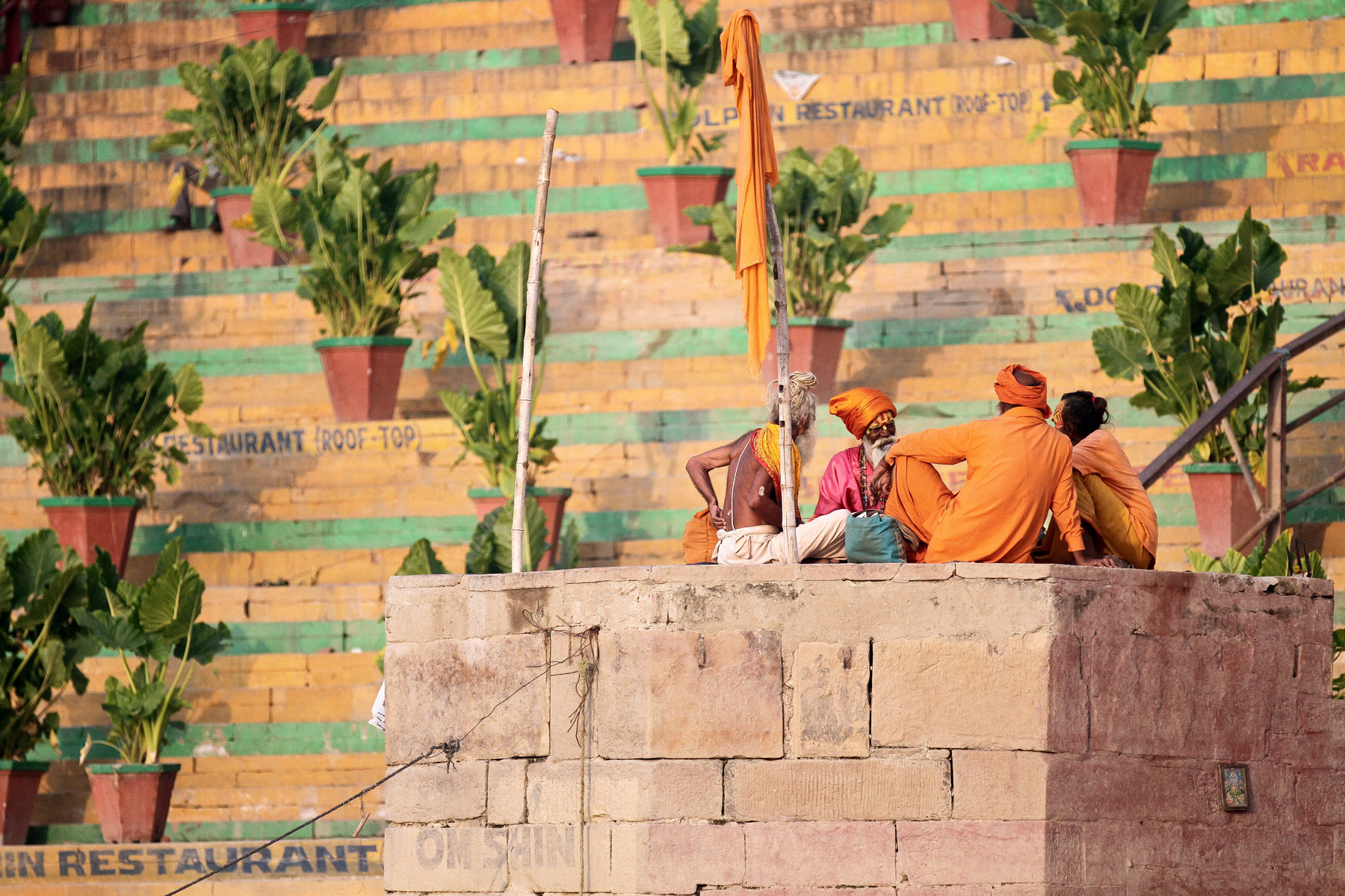 Holy men sitting on the edge of the Ganges River in Varanasi, India