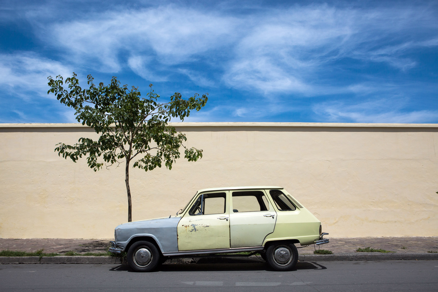 A yellow car in front of a yellow wall in Salta, Argentina