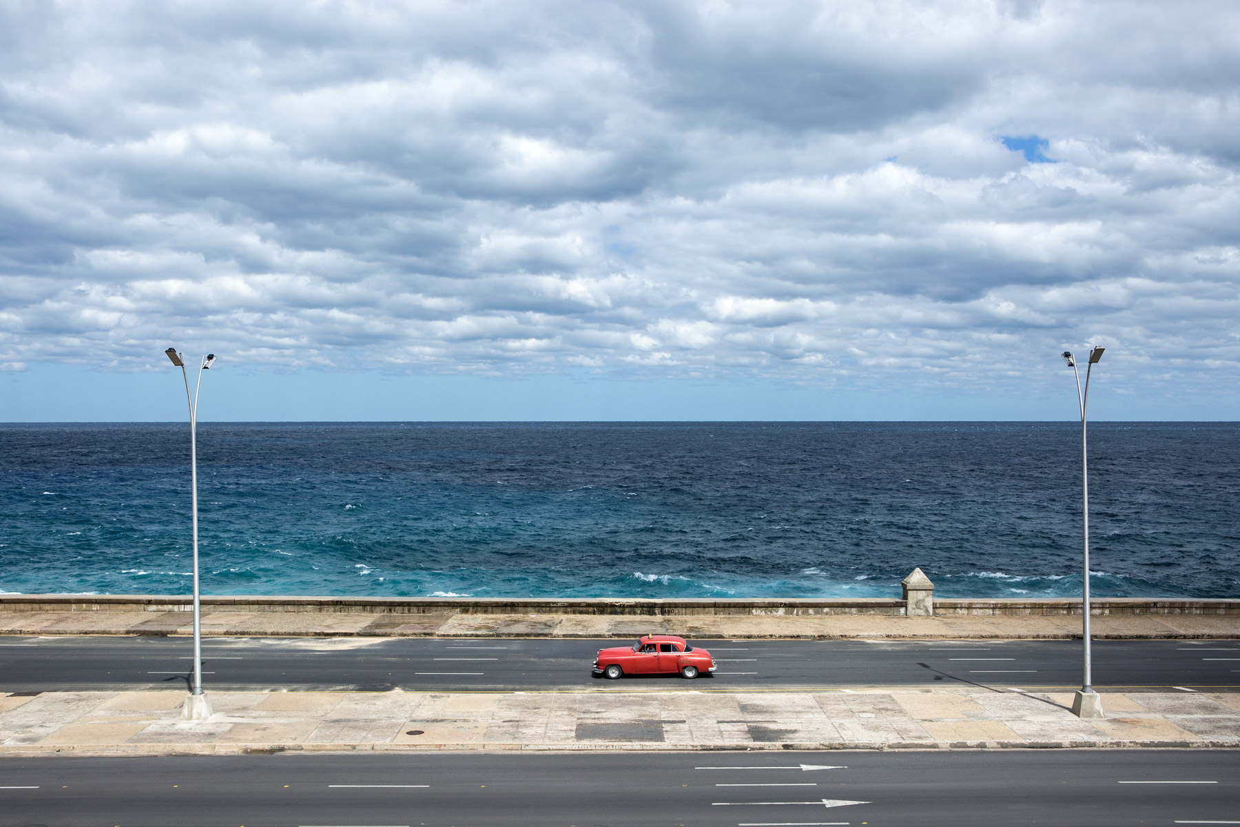 A classic American car driving along the Malecon in Havana, Cuba