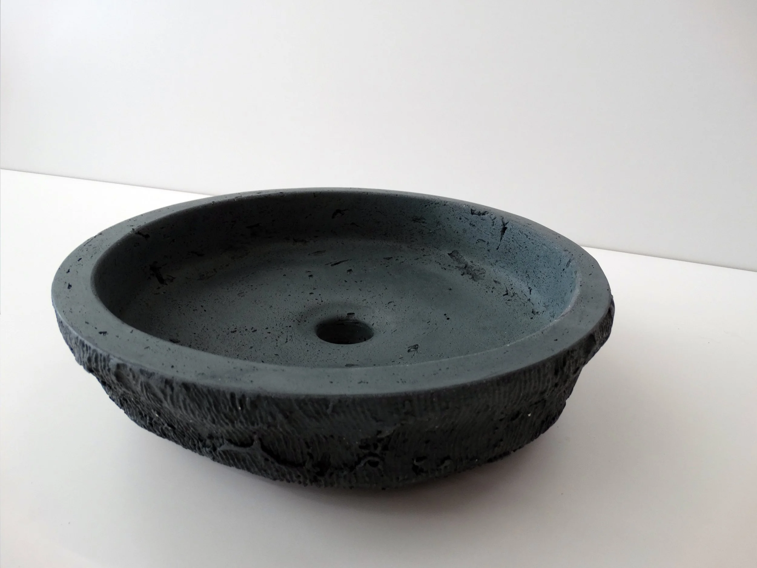 This is BONNI - a handshaped round concrete basin with an organic shape and a truly unique texture. Suitable for surface mounting, this concrete basin will be a focal point in your bathroom design.