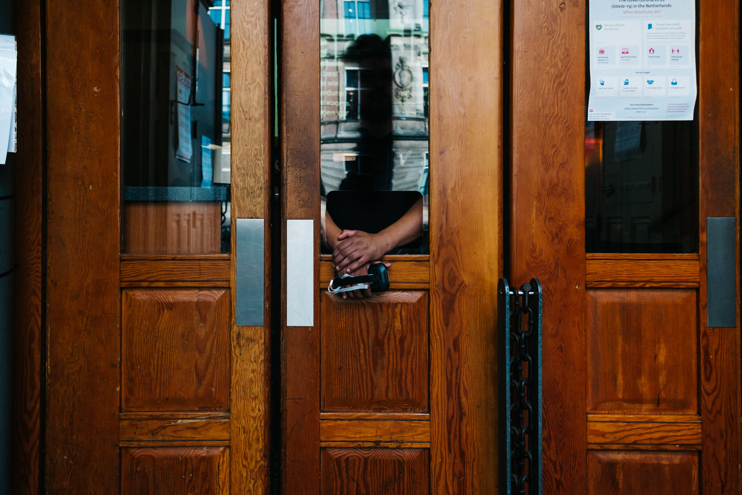  A Paradiso security guard waits behind a protective plastic screen for visitors of a Claw Boys Claw concert at Paradiso, Amsterdam, August 28, 2020. 