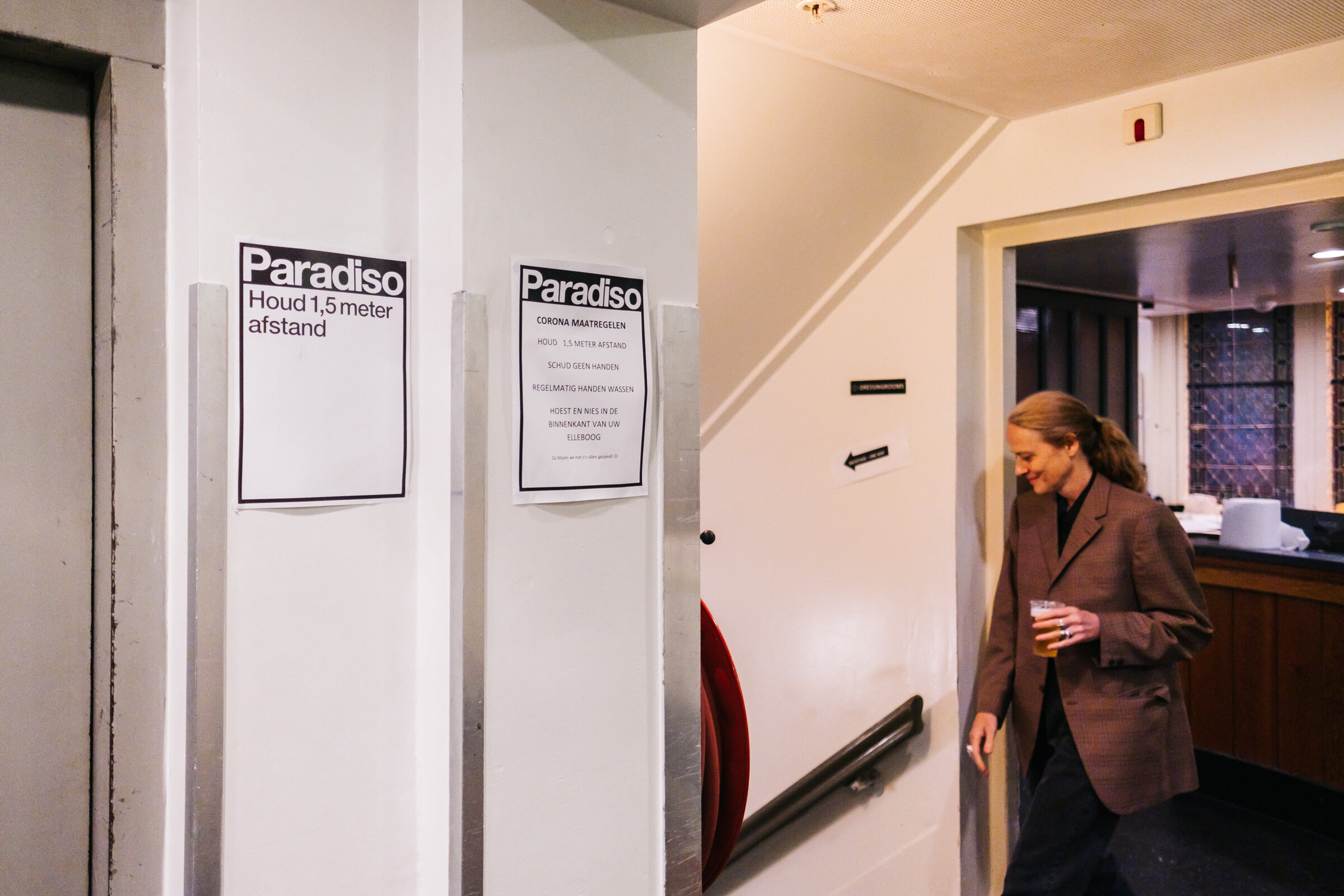  Someone heads for the backstage area, now one-way because of the small hallways, located underneath Paradiso, Amsterdam, August 28, 2020. Reminders to keep 1.5-metre distance, the Paradiso COVID rules, and direction signs have been printed and sprea