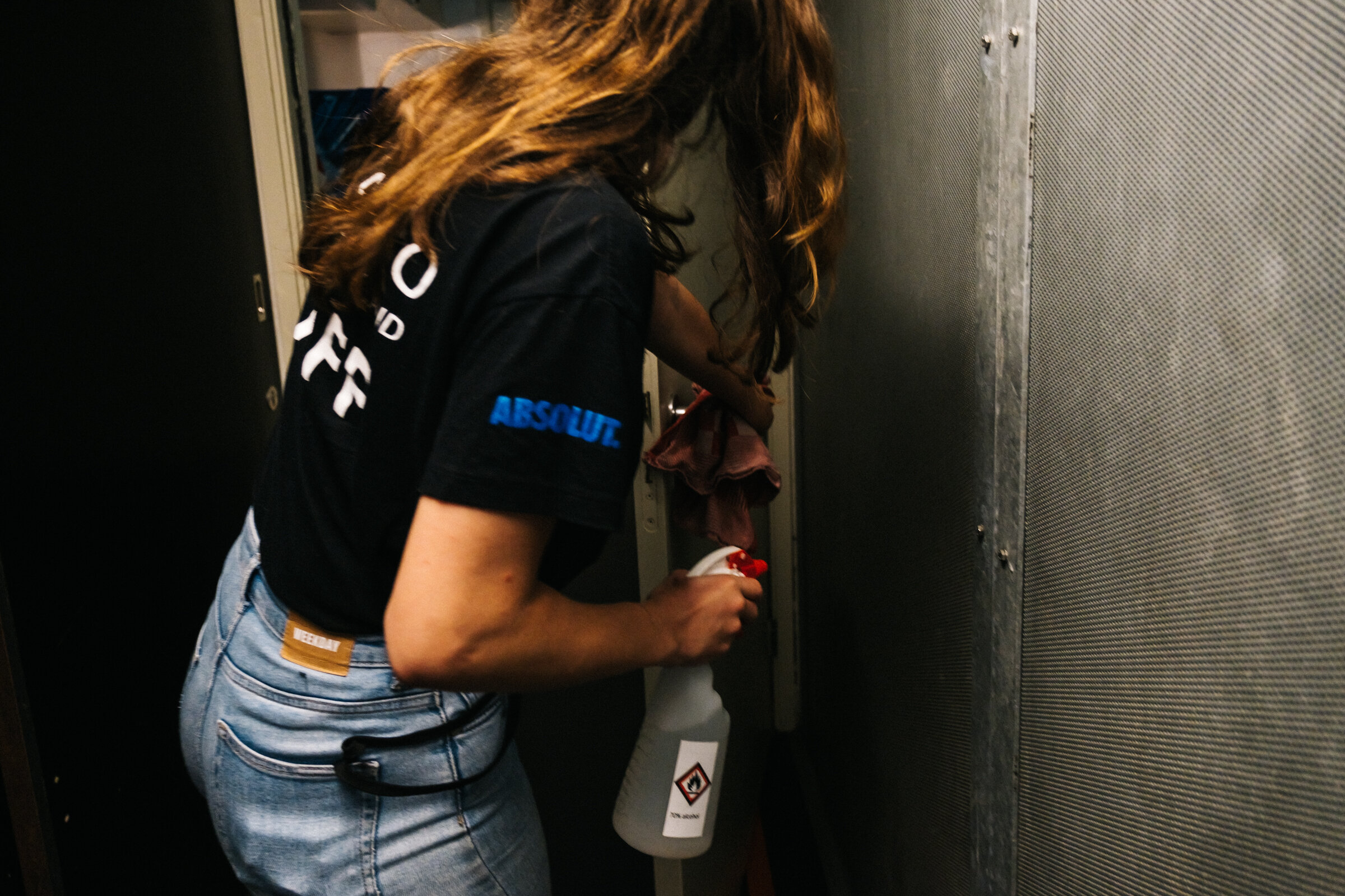  A Paradiso staff member cleans a door in the backstage area at Paradiso, Amsterdam, August 25, 2020. Multiple times a day, staff clean all surfaces and objects such as doorknobs and handrails.  