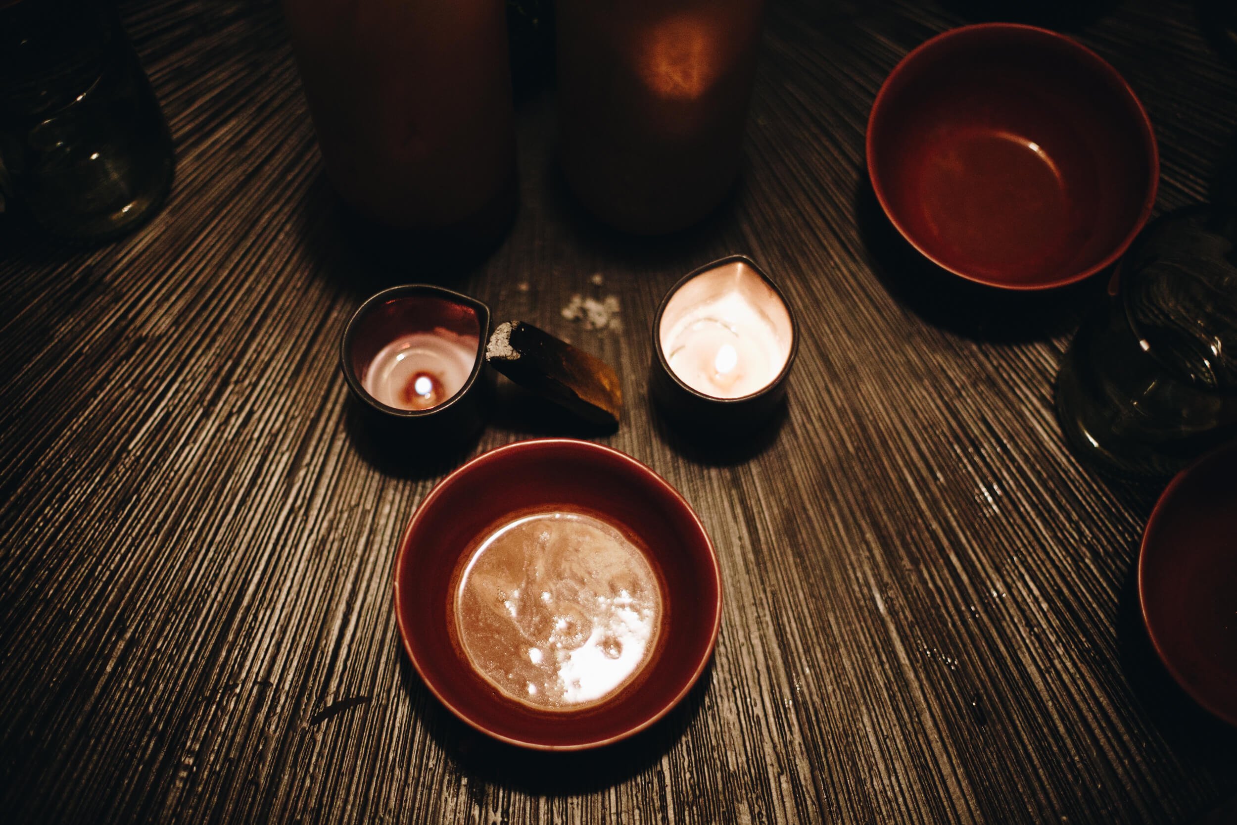 Bowl of ceremonial cacao with candles