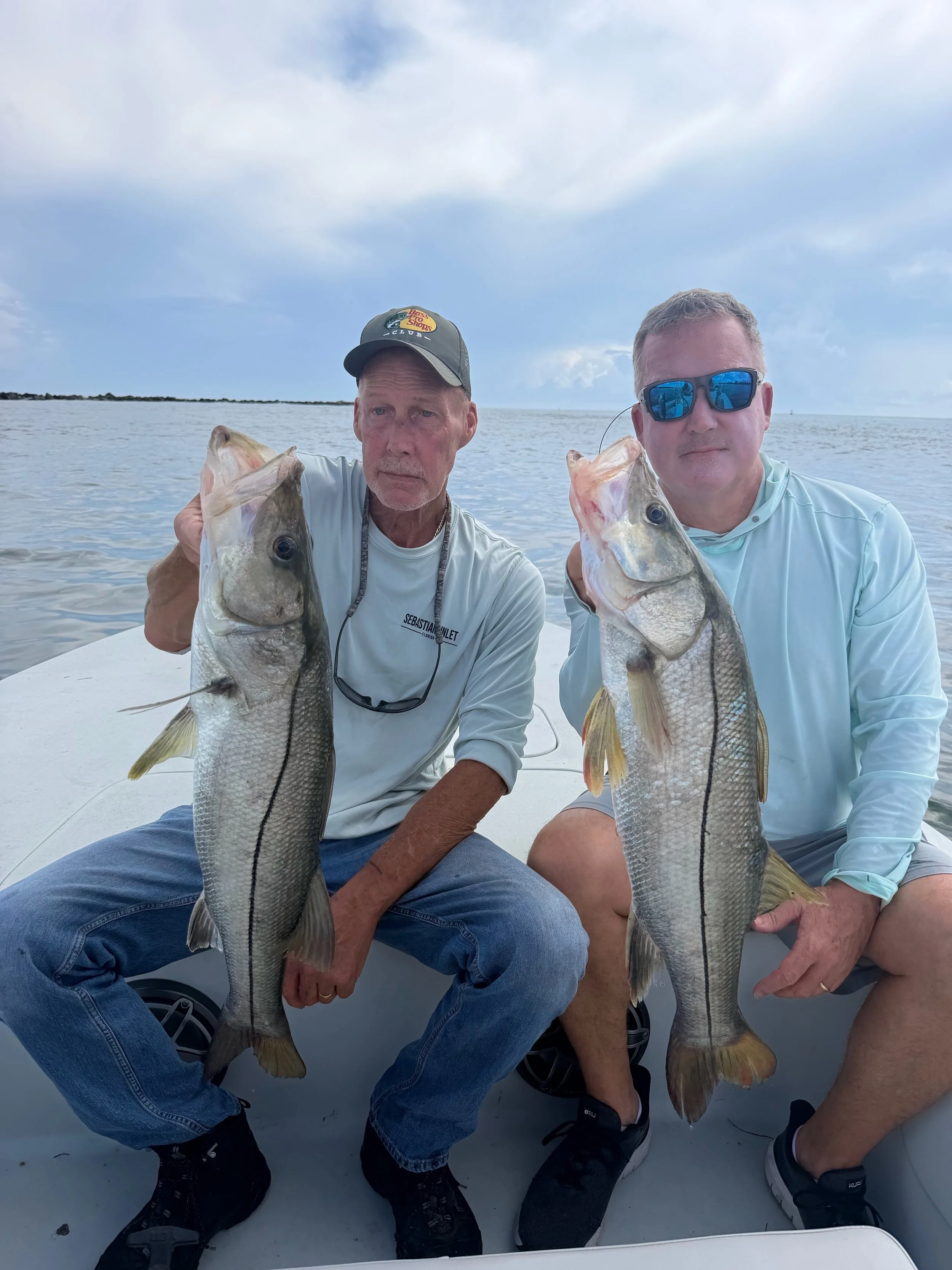 Two anglers holding snook on a Dirty Bird Charters trip near Sebastian, FL