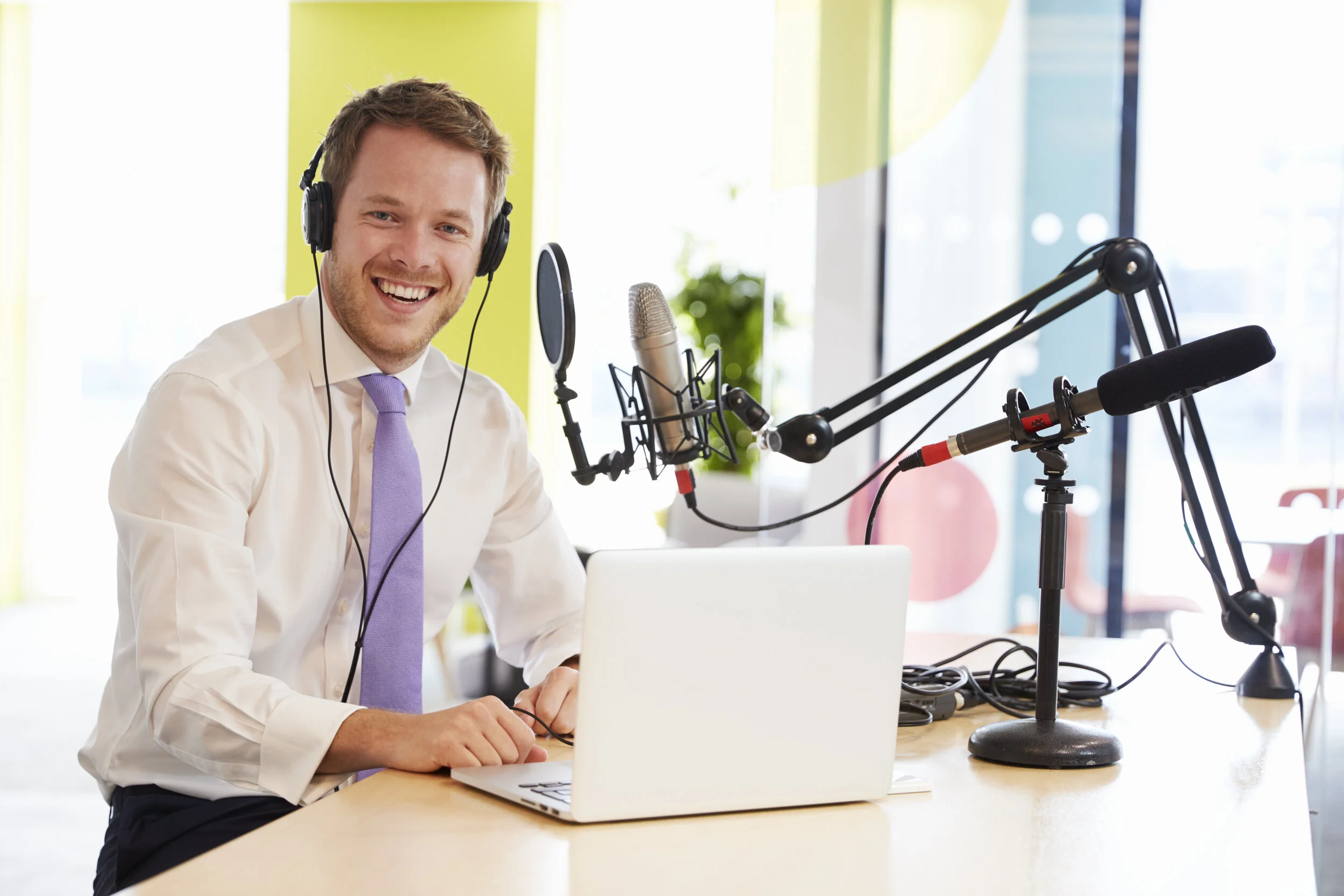 young-man-recording-a-podcast-smiling-to-camera-PQPF7YE.jpg