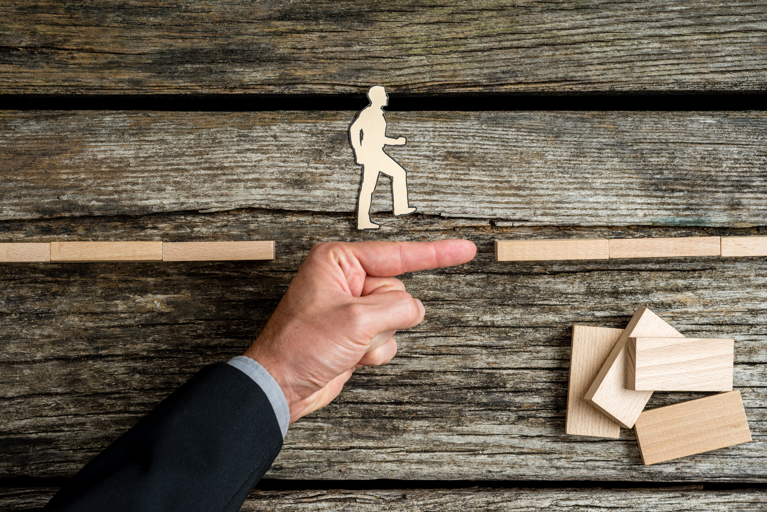 businessman-supporting-paper-cut-out-of-a-man-walk-P5J27KZ.jpg