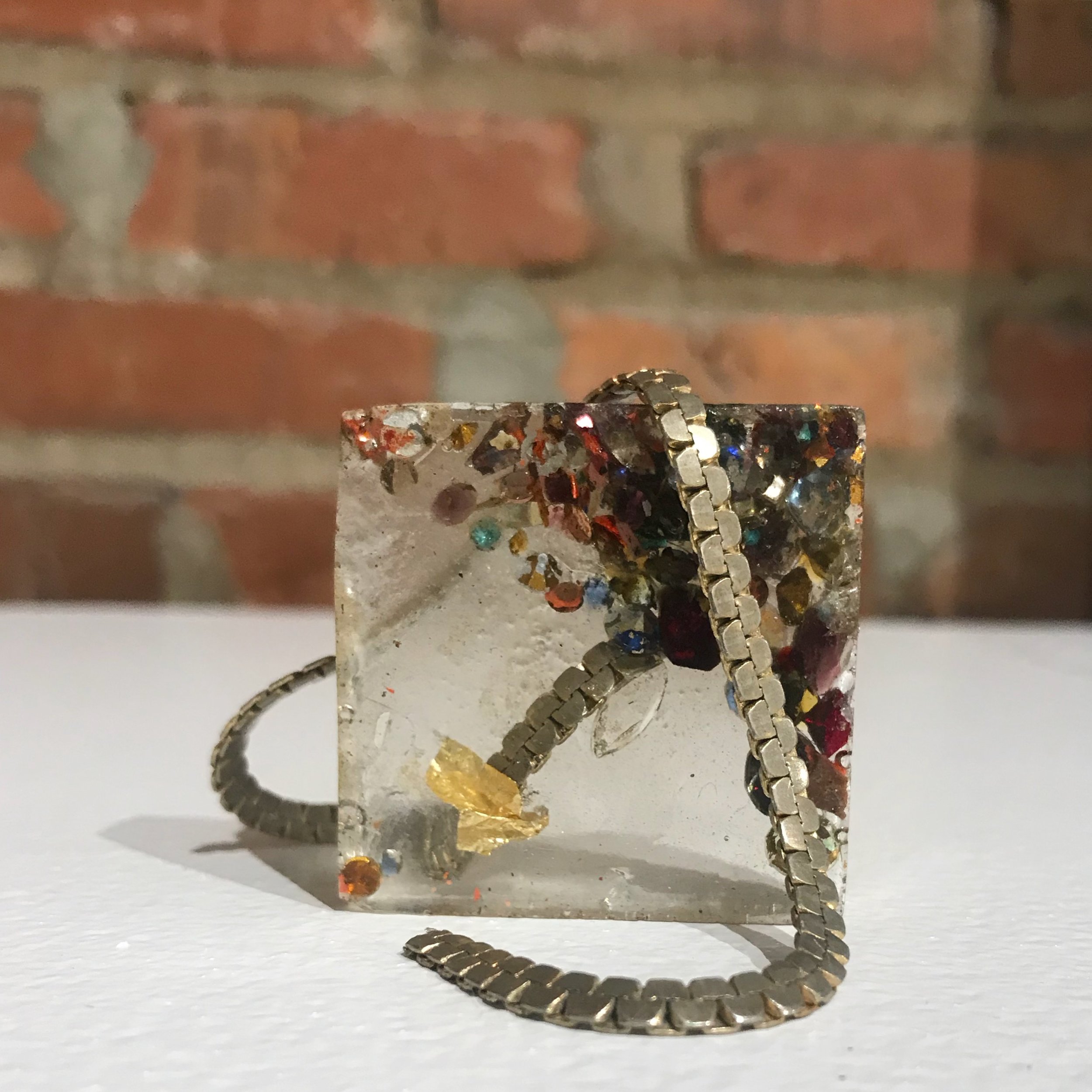  Sugar Cube , 2019, rhinestones, gold leaf, and silver chain cast in resin, 2x2 