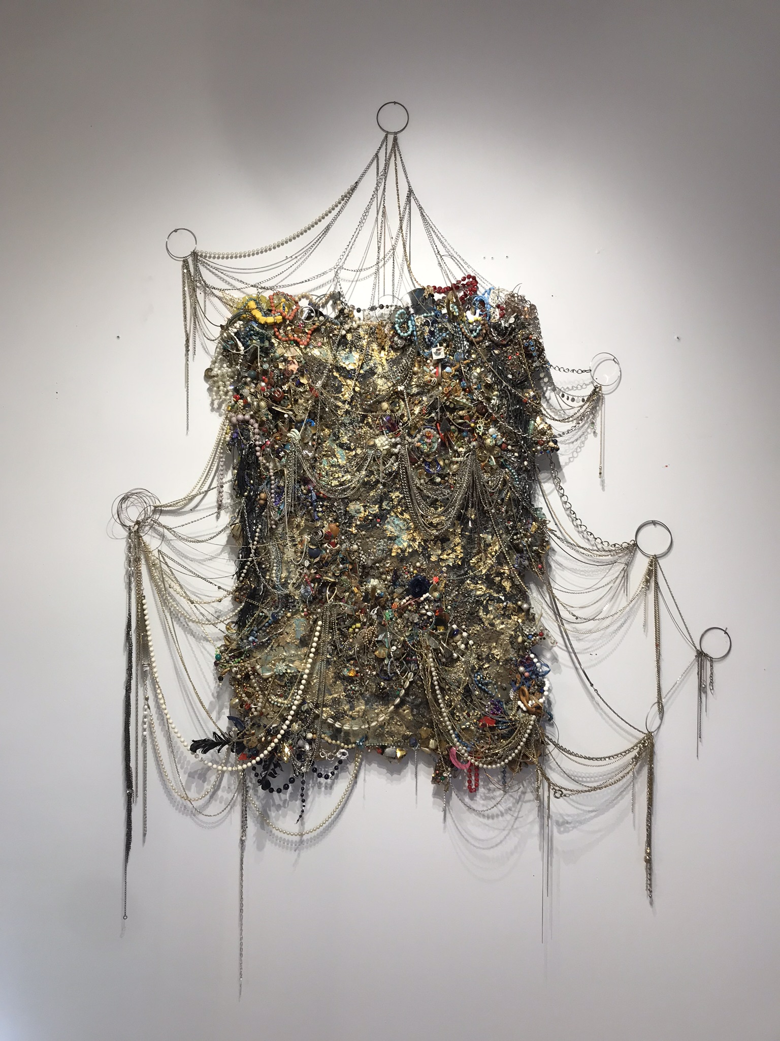   Embroachment,  2019, costume jewelry, plaster, gold leaf, chain, and resin on panel, approx. 45x34” 