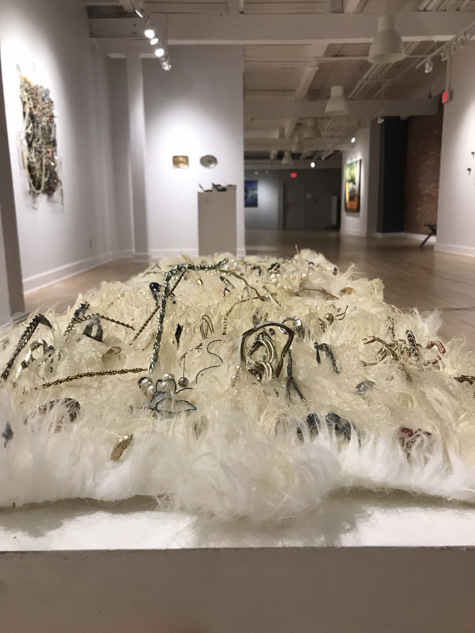   Faux Fur,  2019, costume jewelry, chains, found objects, and resin on faux fur, 16x48” 