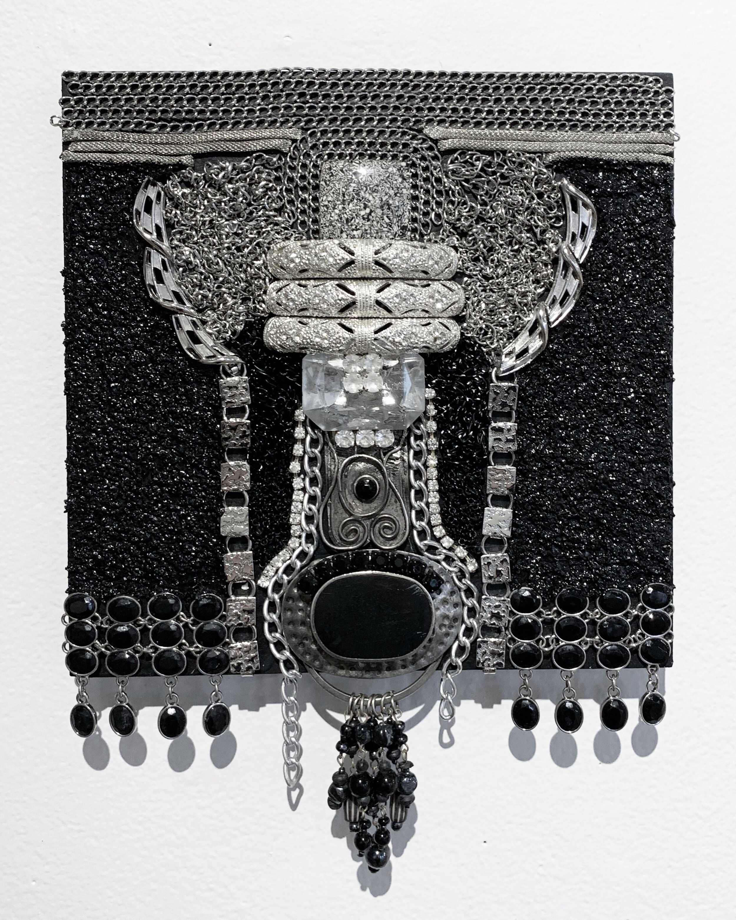   Cadillac,  2020, costume jewelry, silver chain, and glass bead medium on panel, 8x8” 