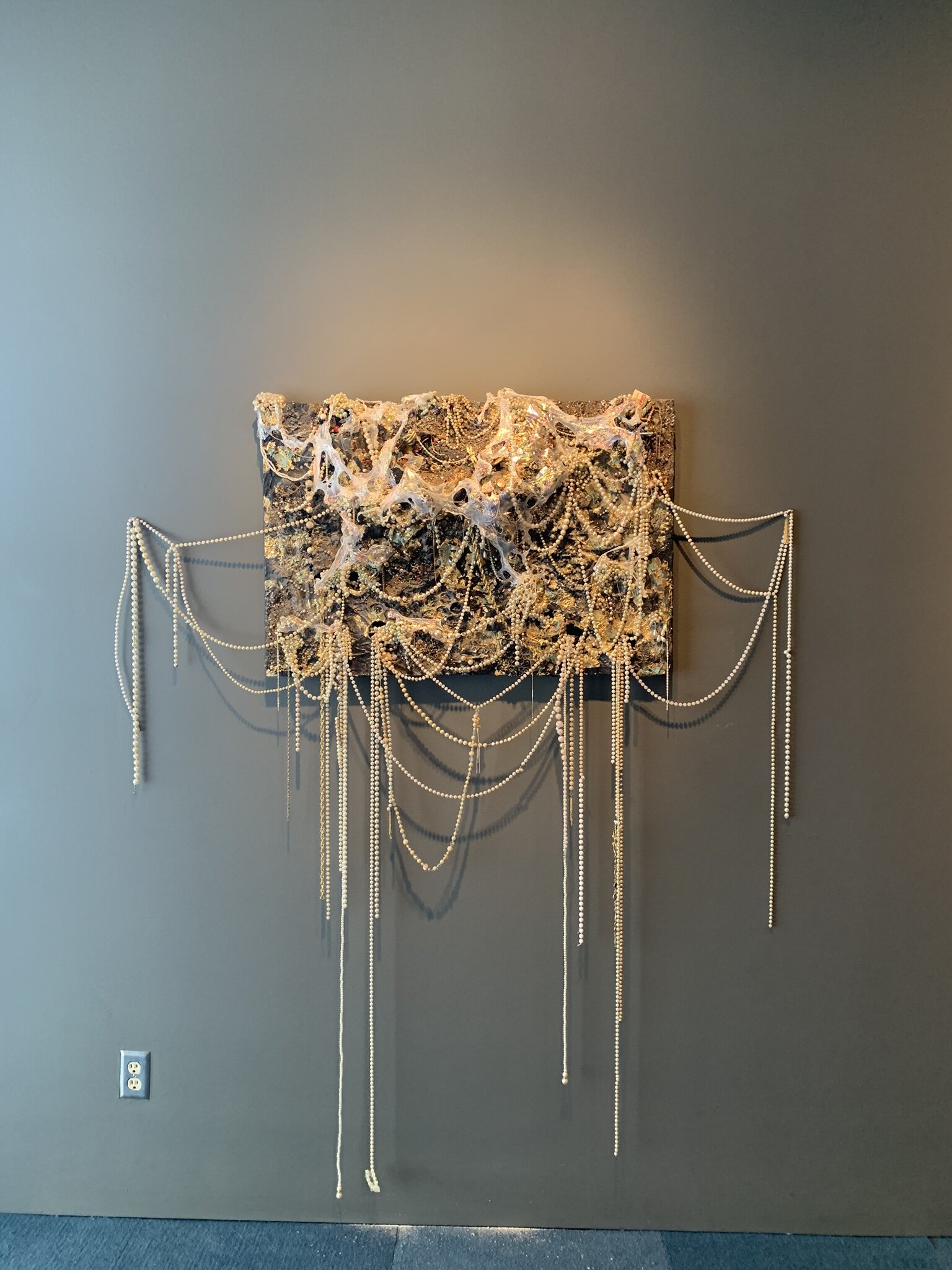   Faux Pearls,  2019, costume jewelry, faux pearls, found objects, metal screen, cellophane, and resin on panel, approx. 36x24"  